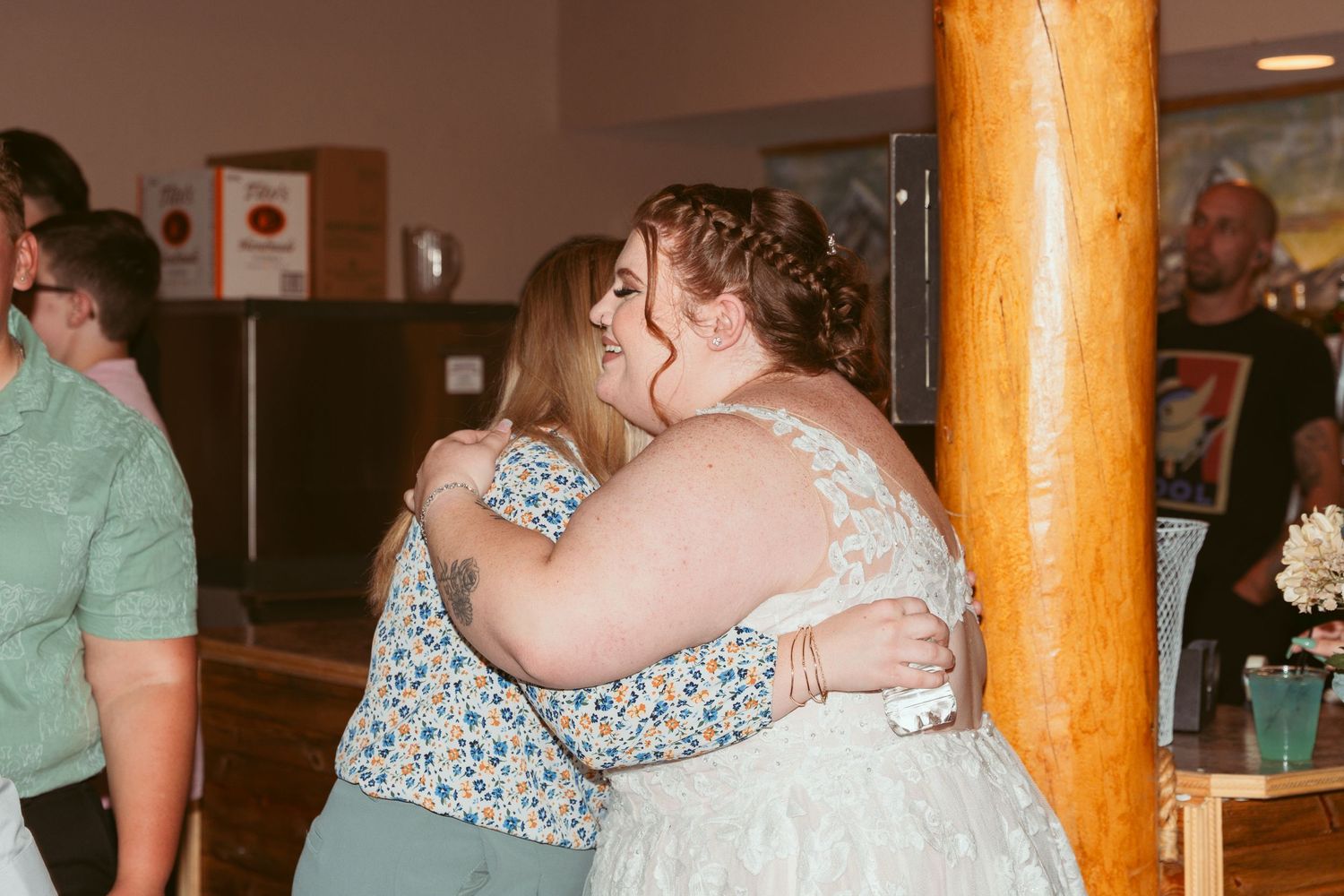 Wedding celebration in a rustic venue with wooden beams and floral decorations.