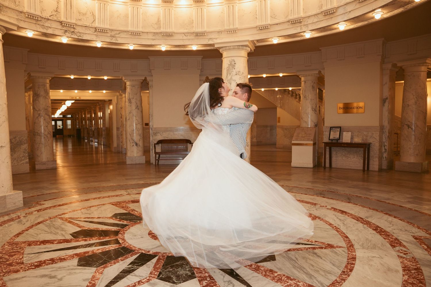 A grand circular ballroom with ornate architecture and dramatic lighting creates an elegant atmosphere.