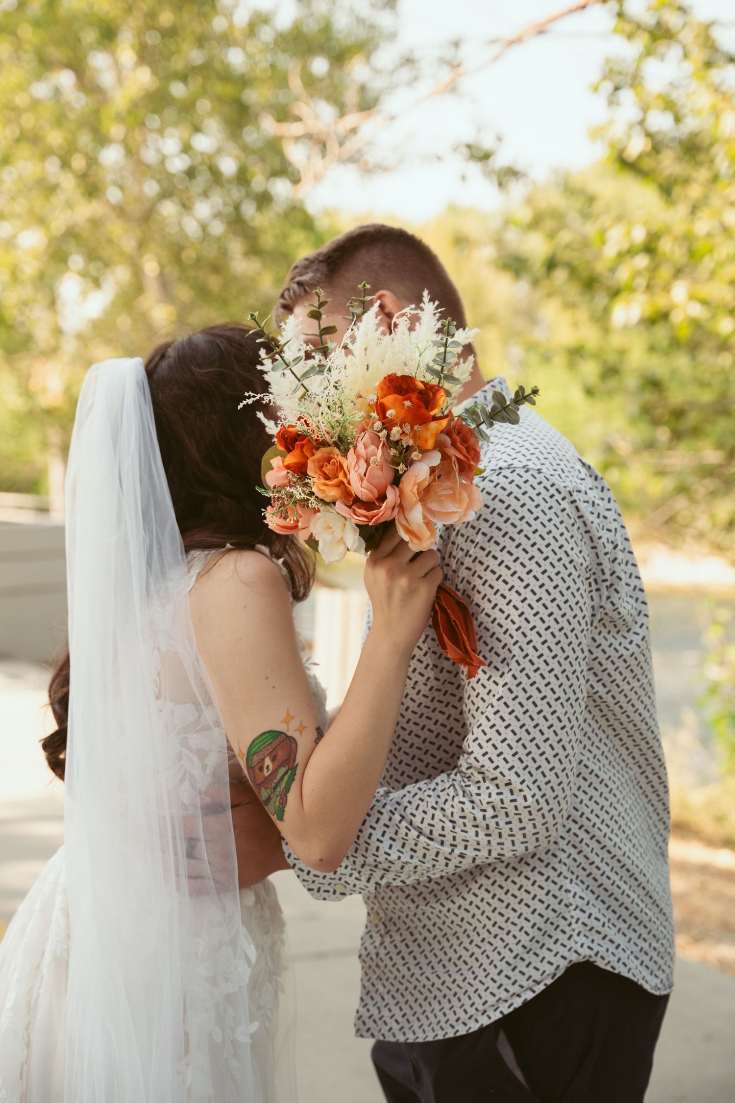 A close-up series of a couple sharing an intimate moment with autumn-colored flowers and a white veil.