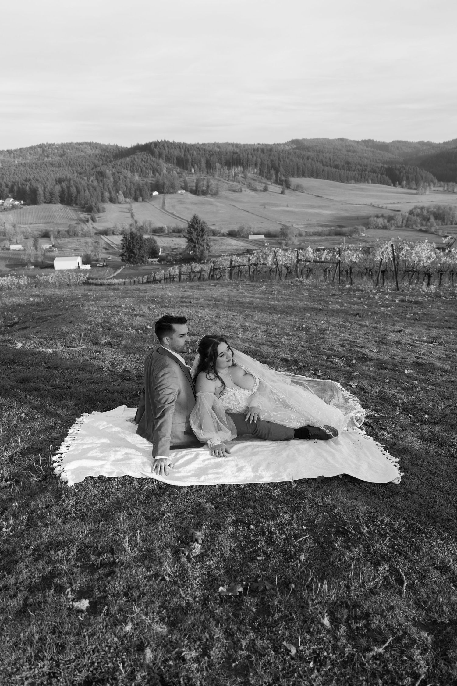 Black and white wedding portrait with mountains and countryside in the distance.