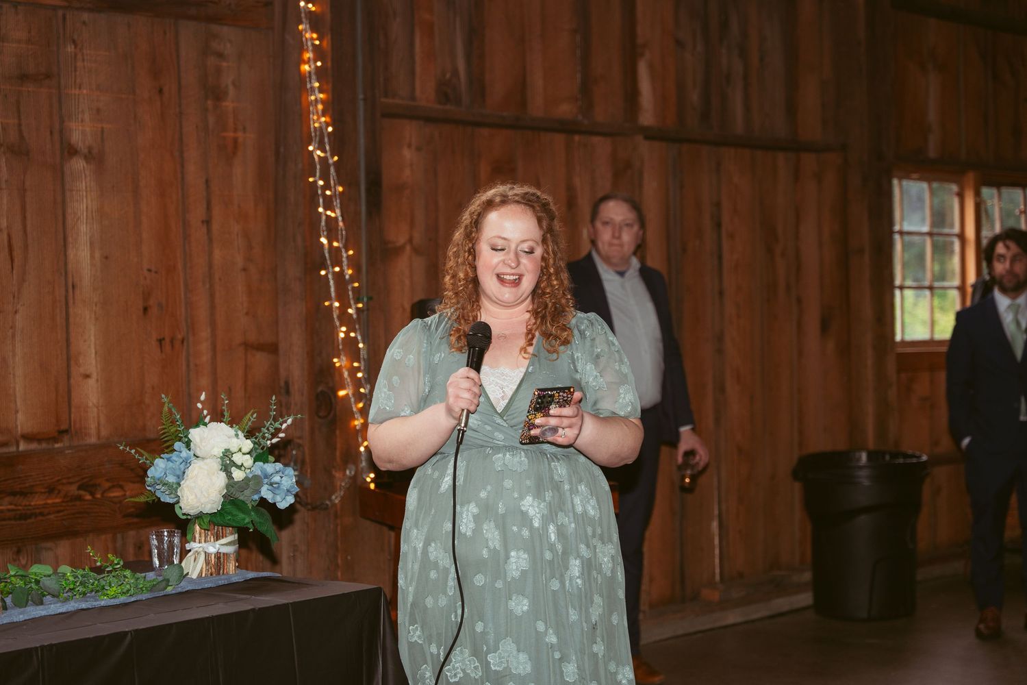 Wedding celebration candid moments captured in a warmly lit barn setting.