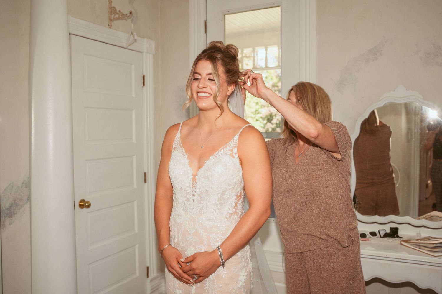Wedding preparations in a light-filled room with white decor and elegant furnishings.