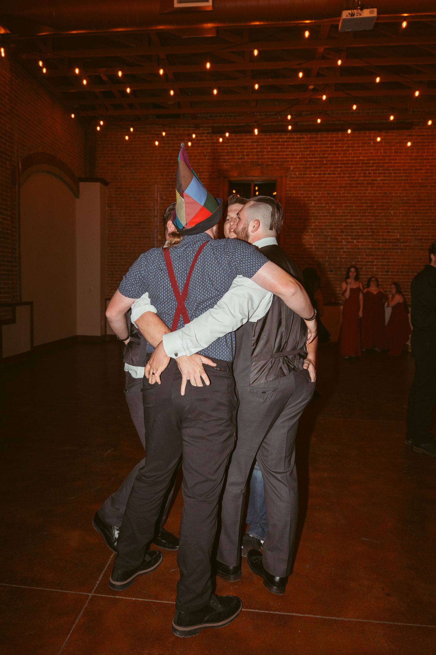Groomsmen performing a choreographed dance routine at a reception venue.