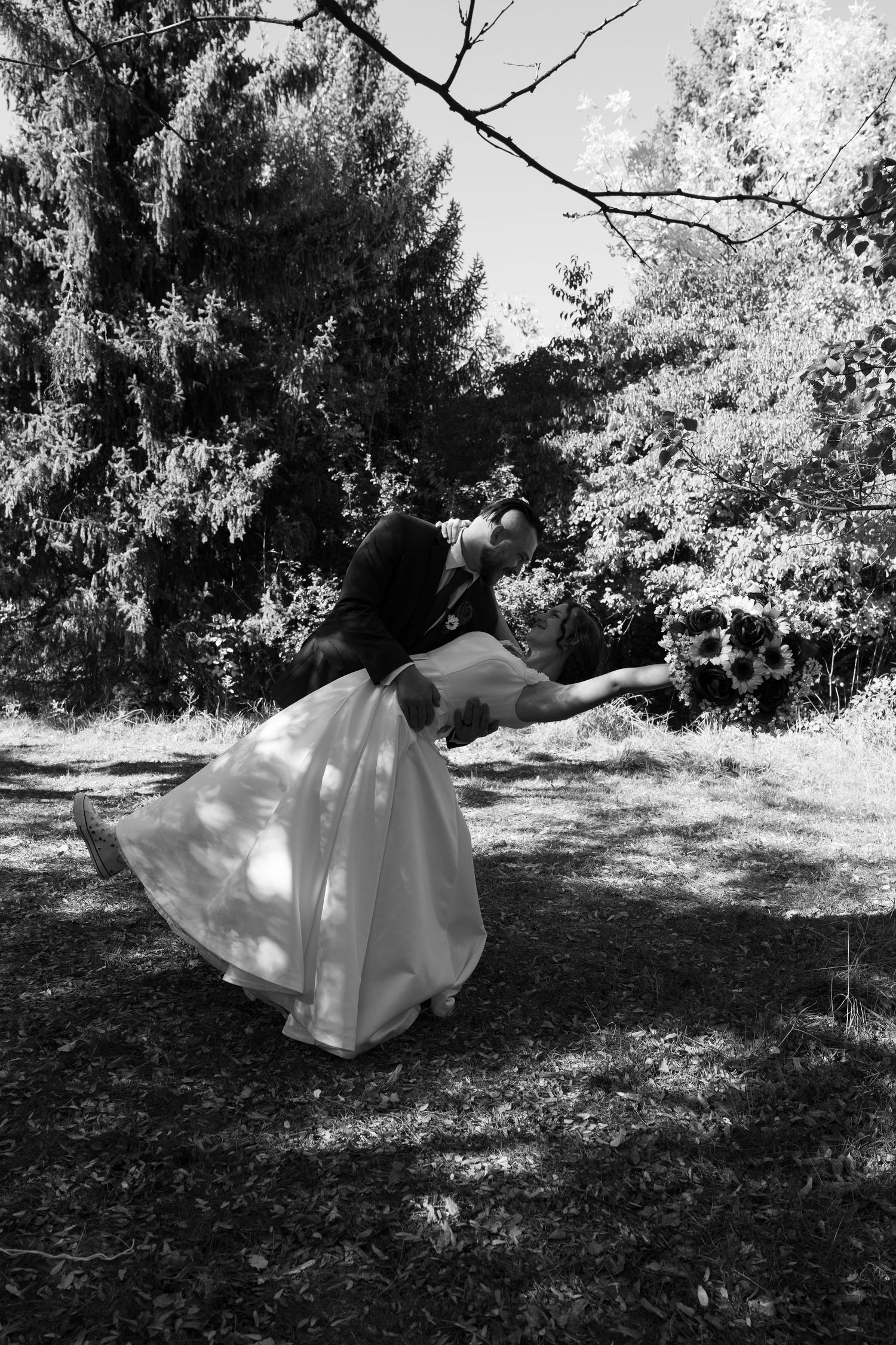 Black and white photo series showing a flowing white wedding dress twirling in a natural outdoor setting.