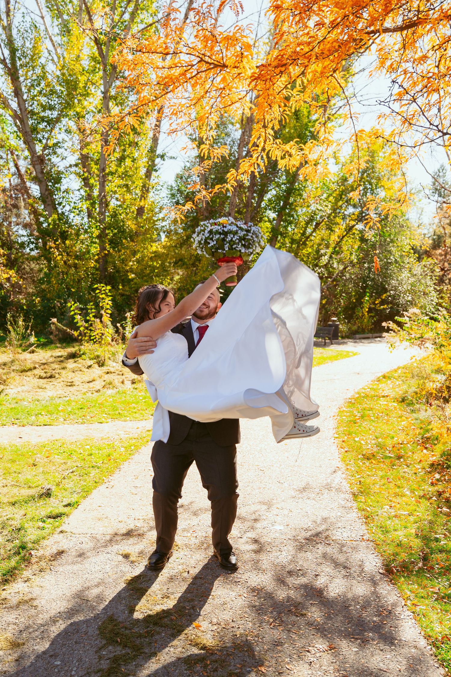 A playful dance dip on a forest trail surrounded by fall colors.