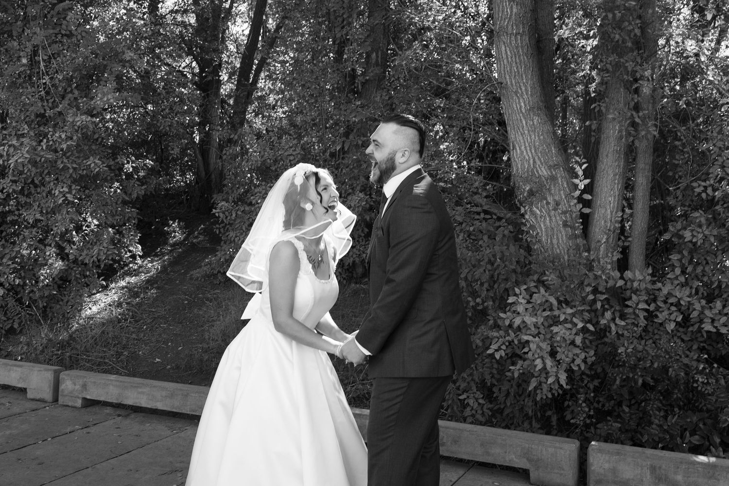 Black and white wedding photography sequence showing tender moments in a natural setting.