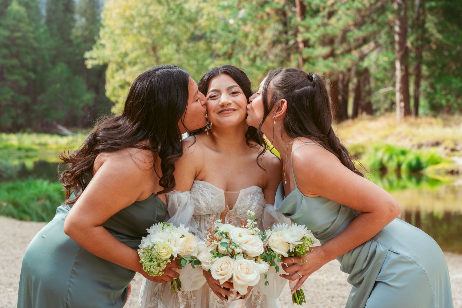 Bridesmaids in blue dresses celebrating with bouquets outdoors.