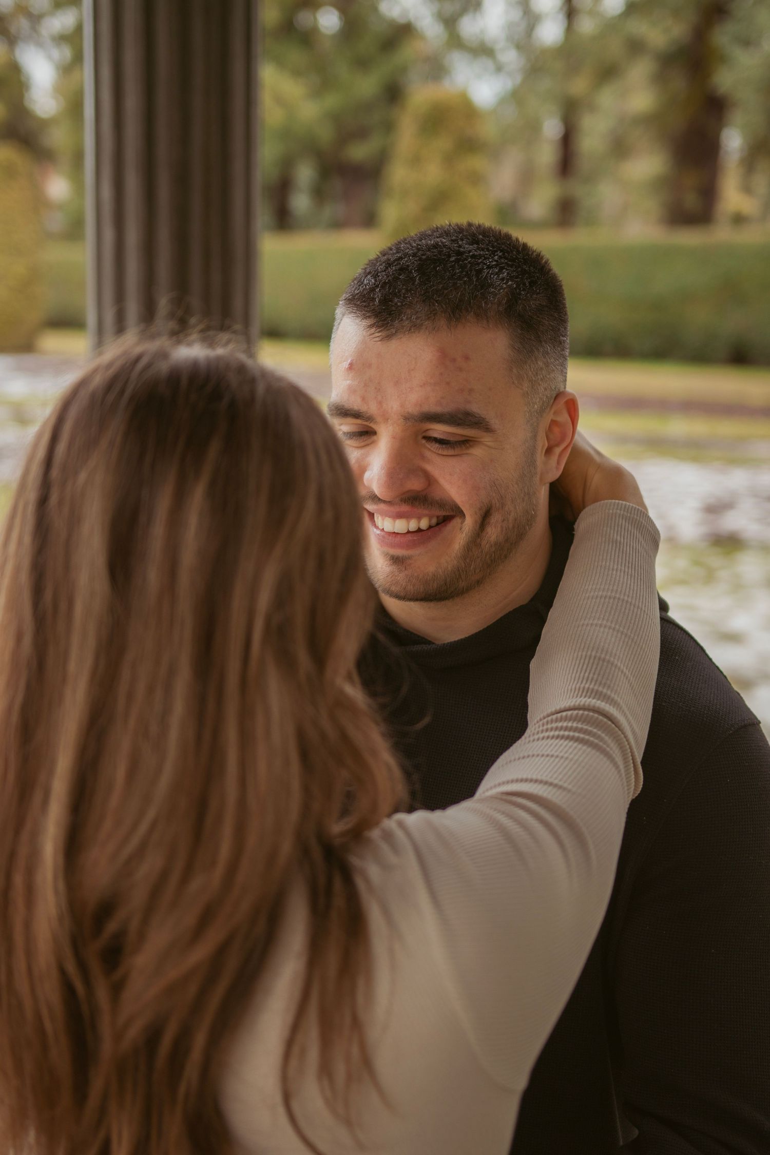 A romantic couple shares tender moments in a park setting with soft lighting.