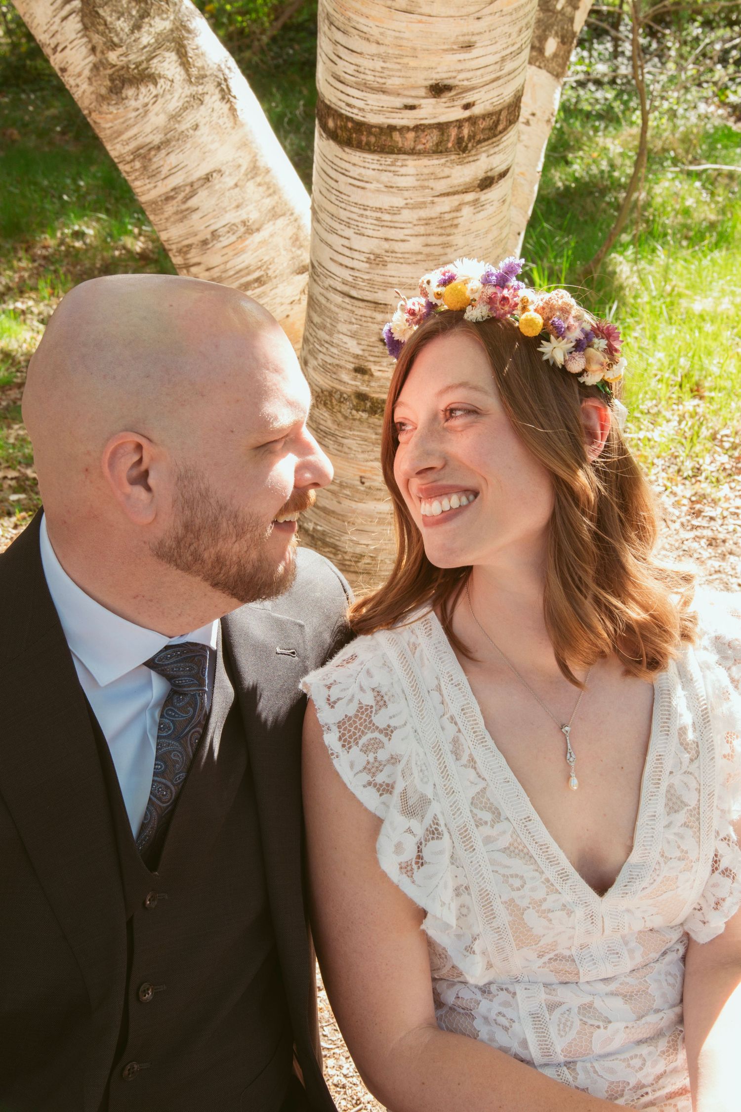 Intimate wedding portraits taken against birch trees with floral crown details.