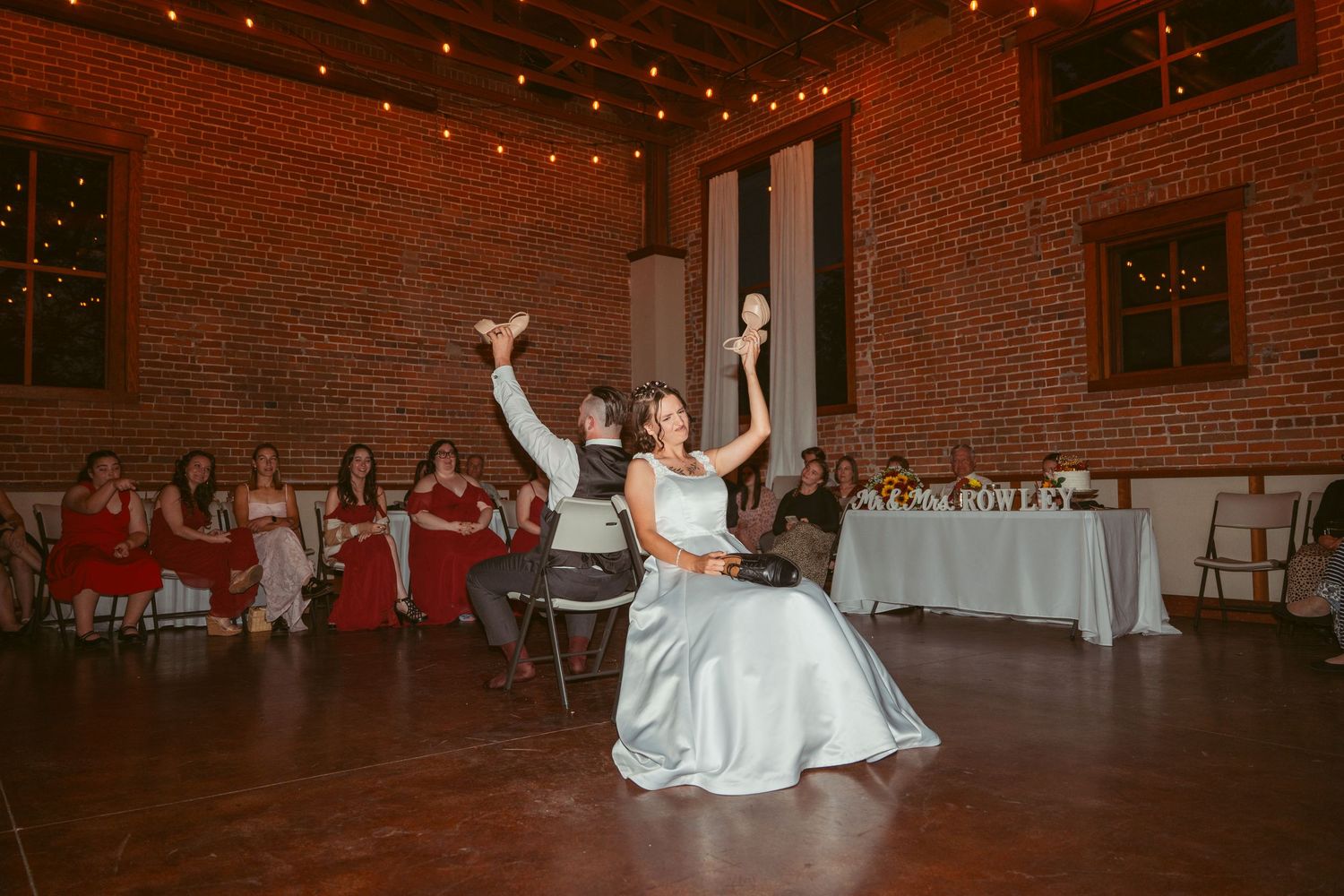 Dancers execute synchronized moves during a wedding reception performance in a rustic venue.