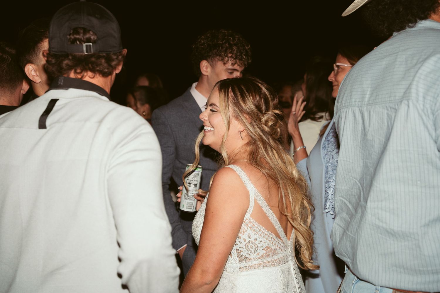 Crowded dance floor at a wedding reception with guests mingling and dancing together.