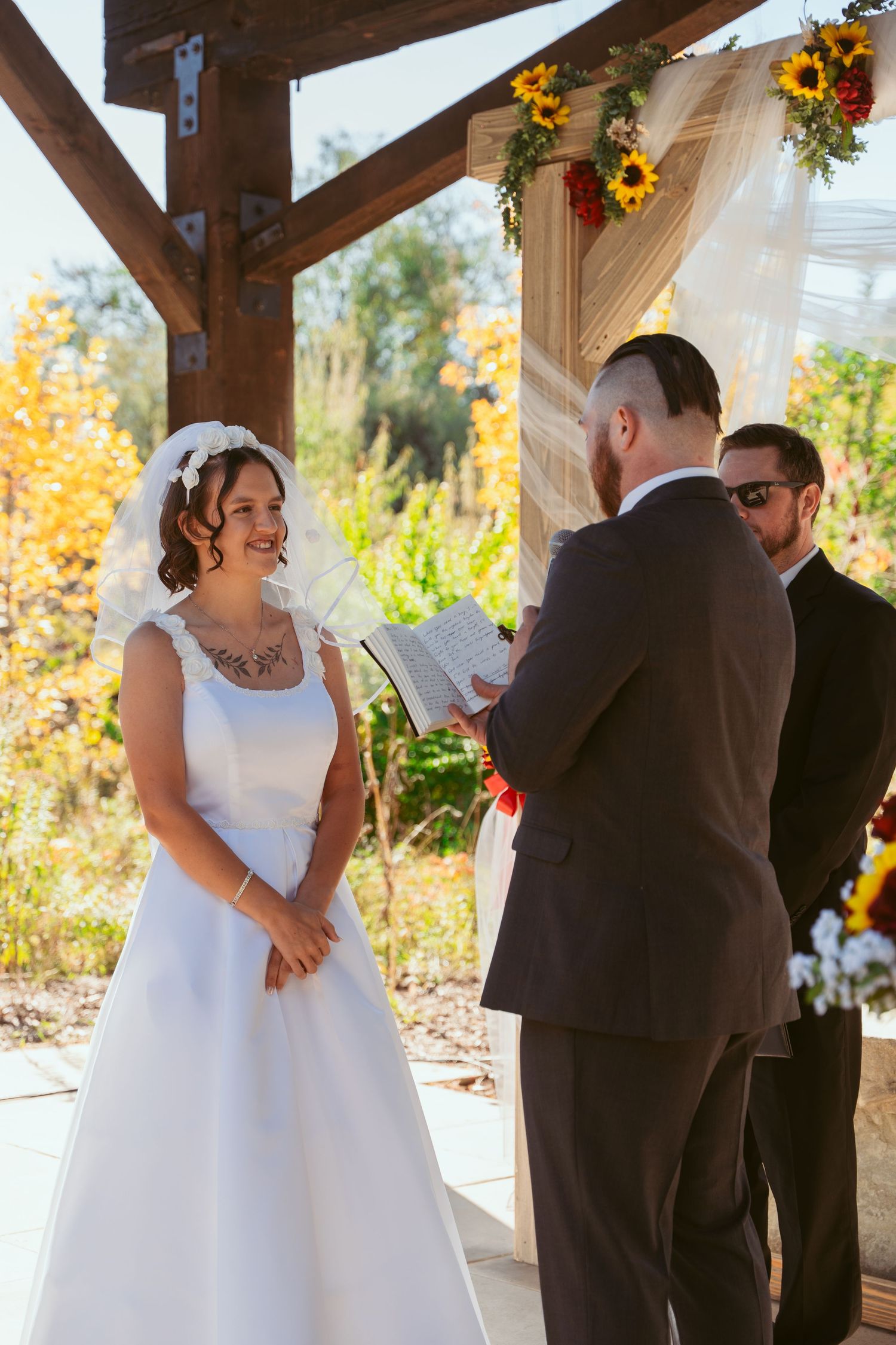 Wedding couple shares tender moments during their autumn ceremony under wooden beams.