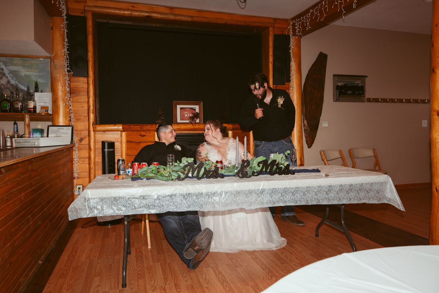 Reception venue interior with rustic log cabin walls and decorative table settings.