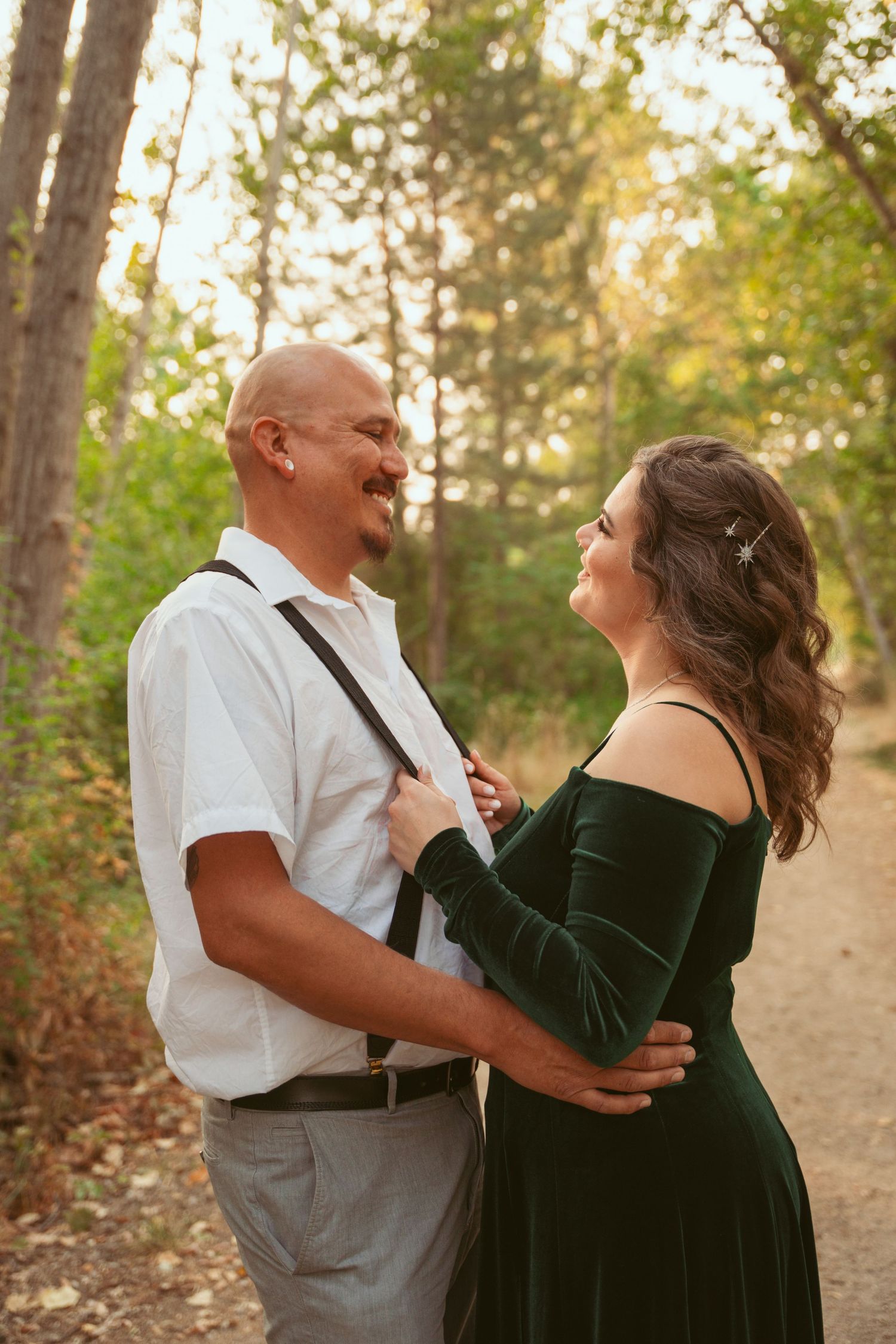 Couple sharing a romantic dance moment on a forest trail.