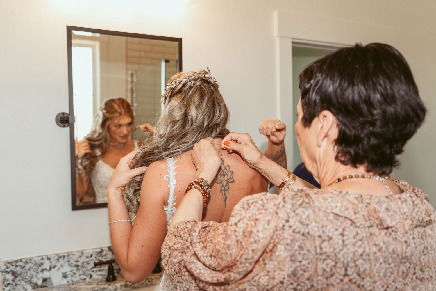 Wedding preparations showing bridesmaids in sparkly dresses helping with final touches.