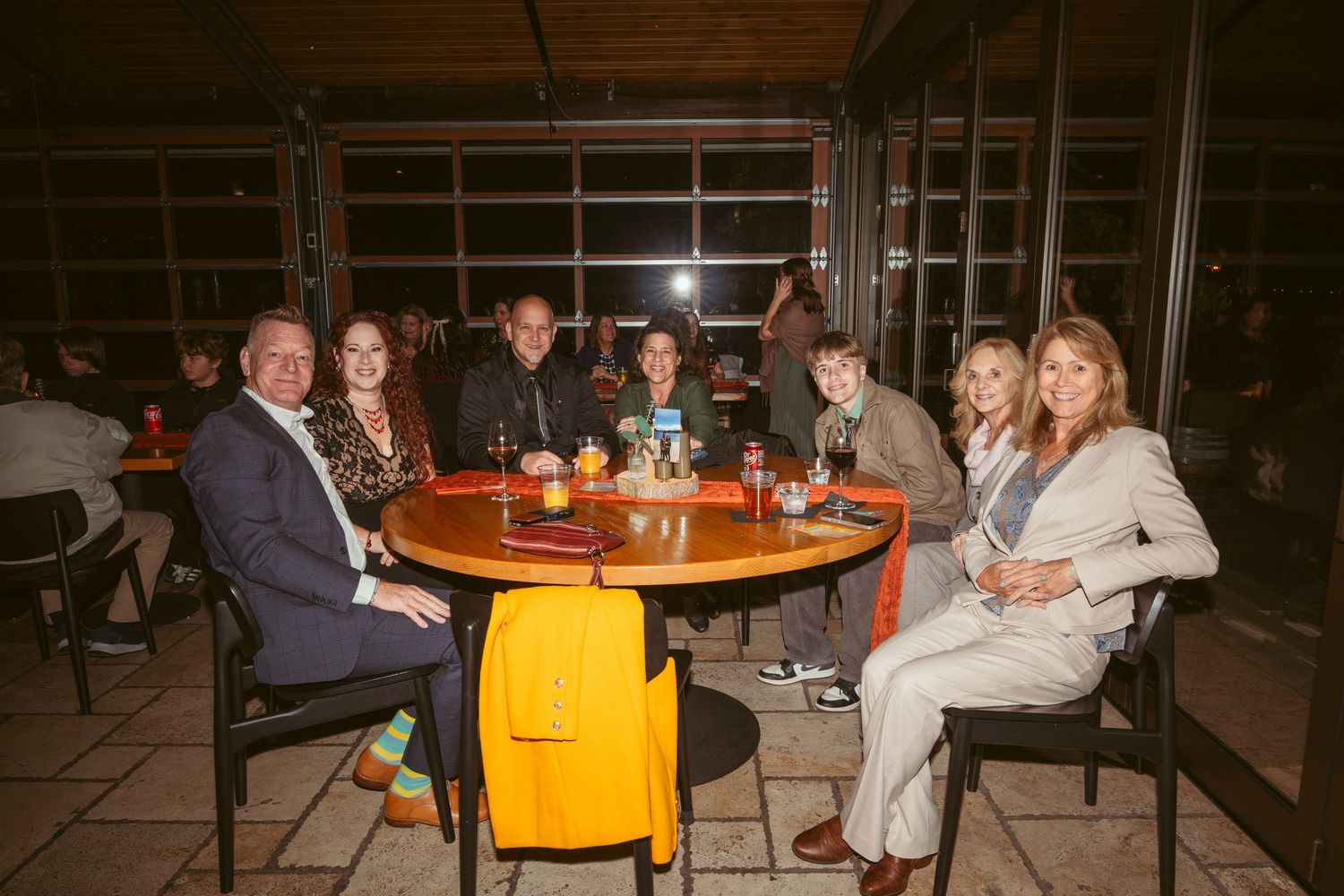 People seated at round tables in a warmly lit indoor venue.