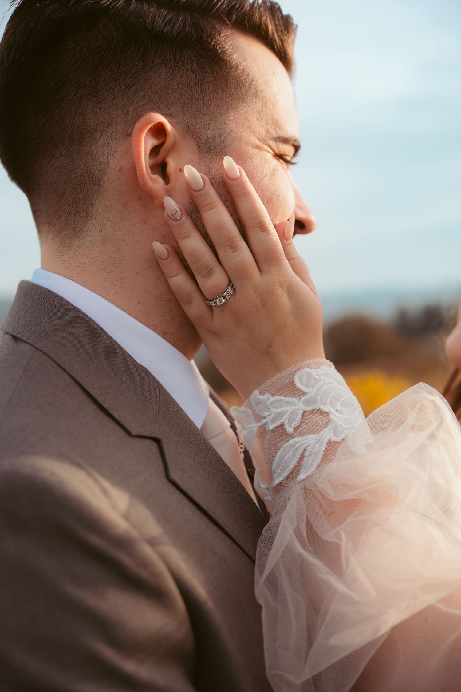 Intimate wedding moment captured against autumn vineyard landscape.