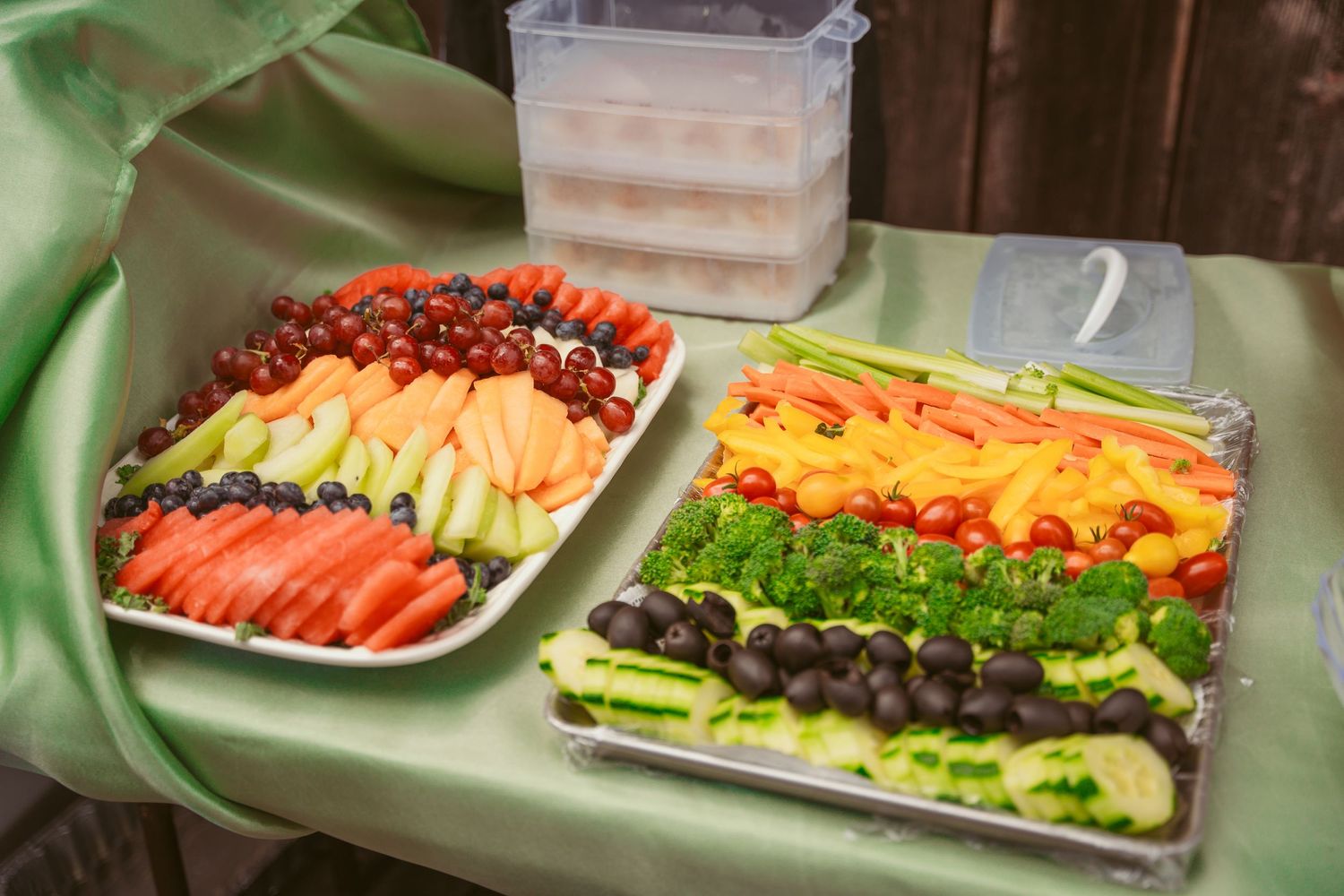 Beautifully arranged vegetable and fruit platters with assorted dips for catering display.