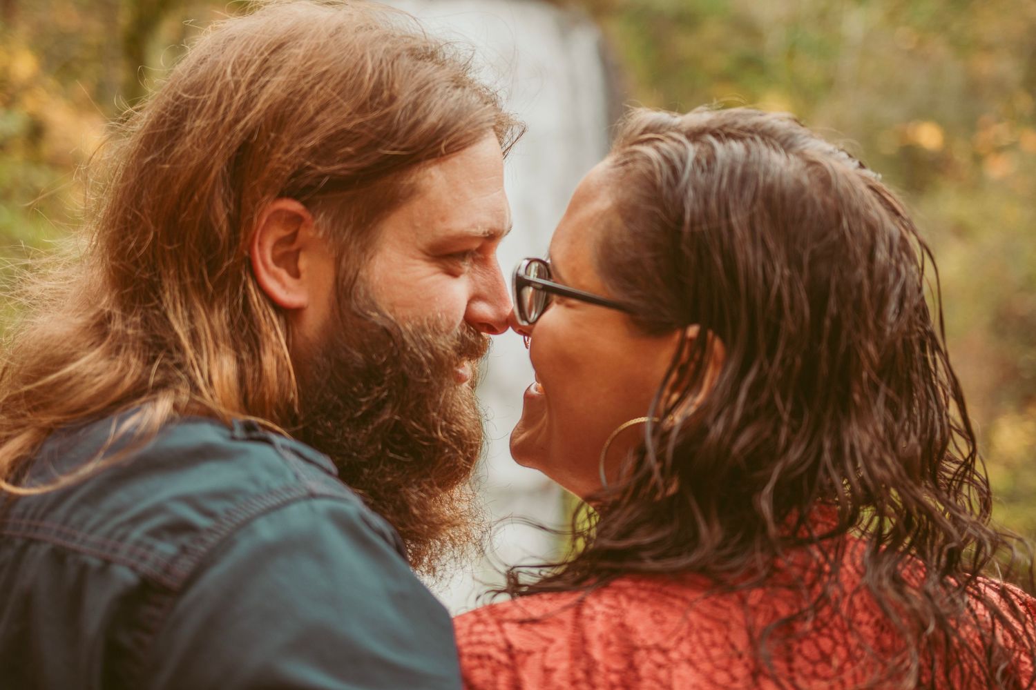 An intimate couple's photoshoot with autumn colors in the background.
