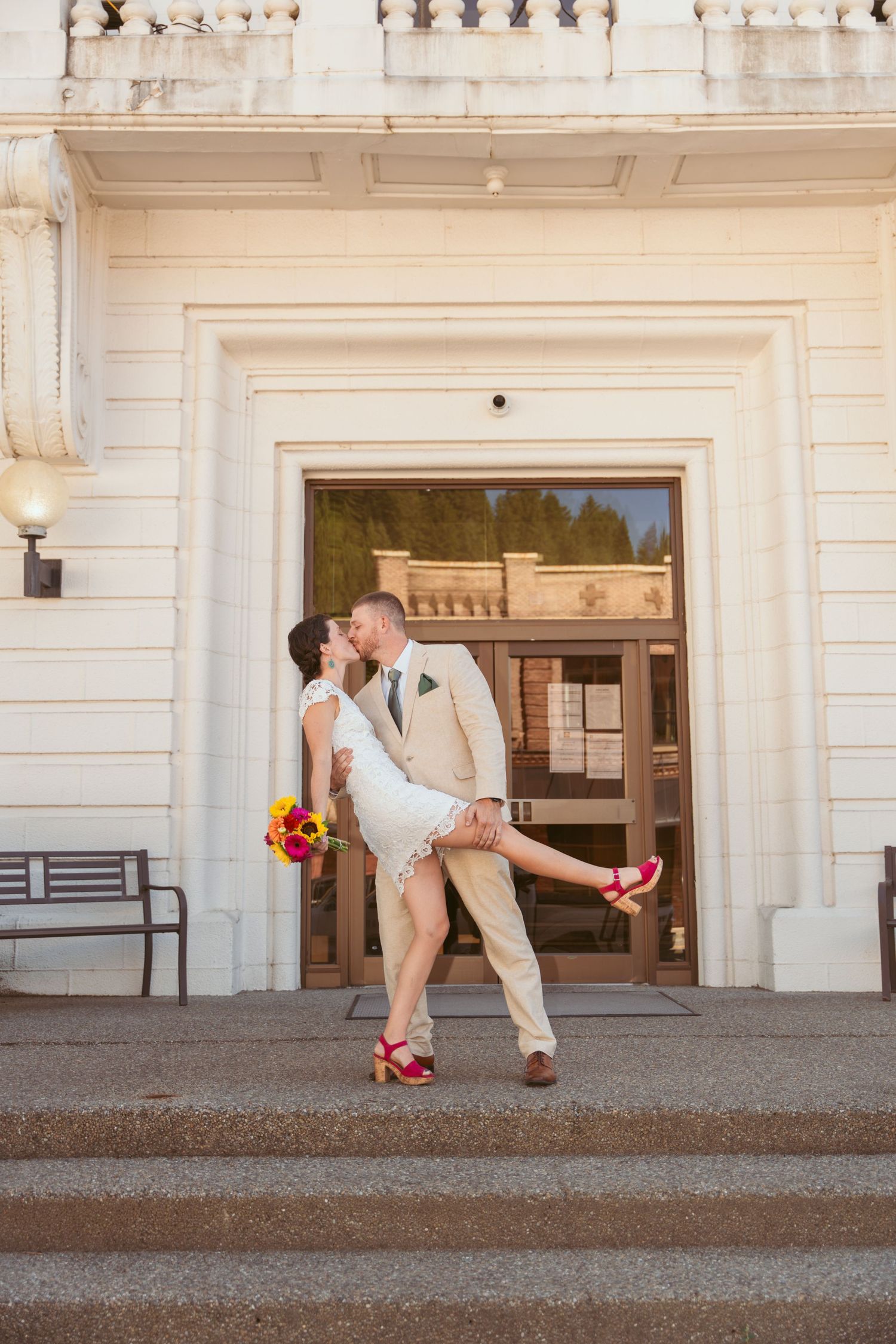 Sequence of playful wedding poses outside a classic white building with columns.