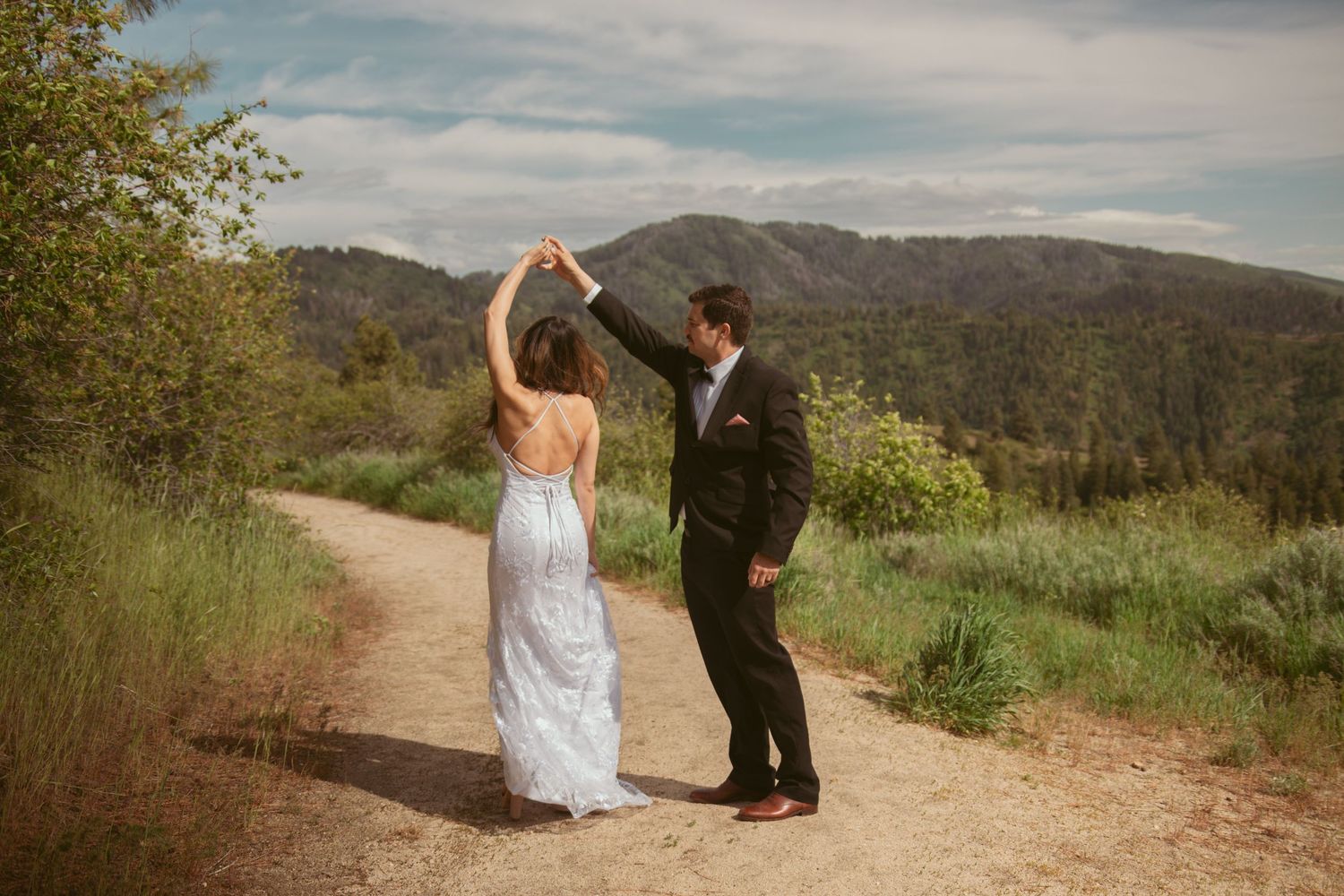 A romantic dance sequence unfolds on a dirt path with mountains and greenery in the background.
