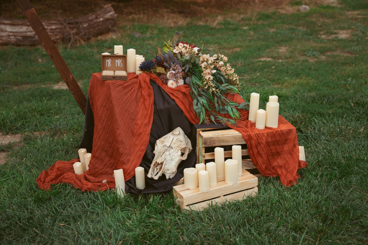 Rustic wooden blocks and red fabric styled on grass in an artistic arrangement.