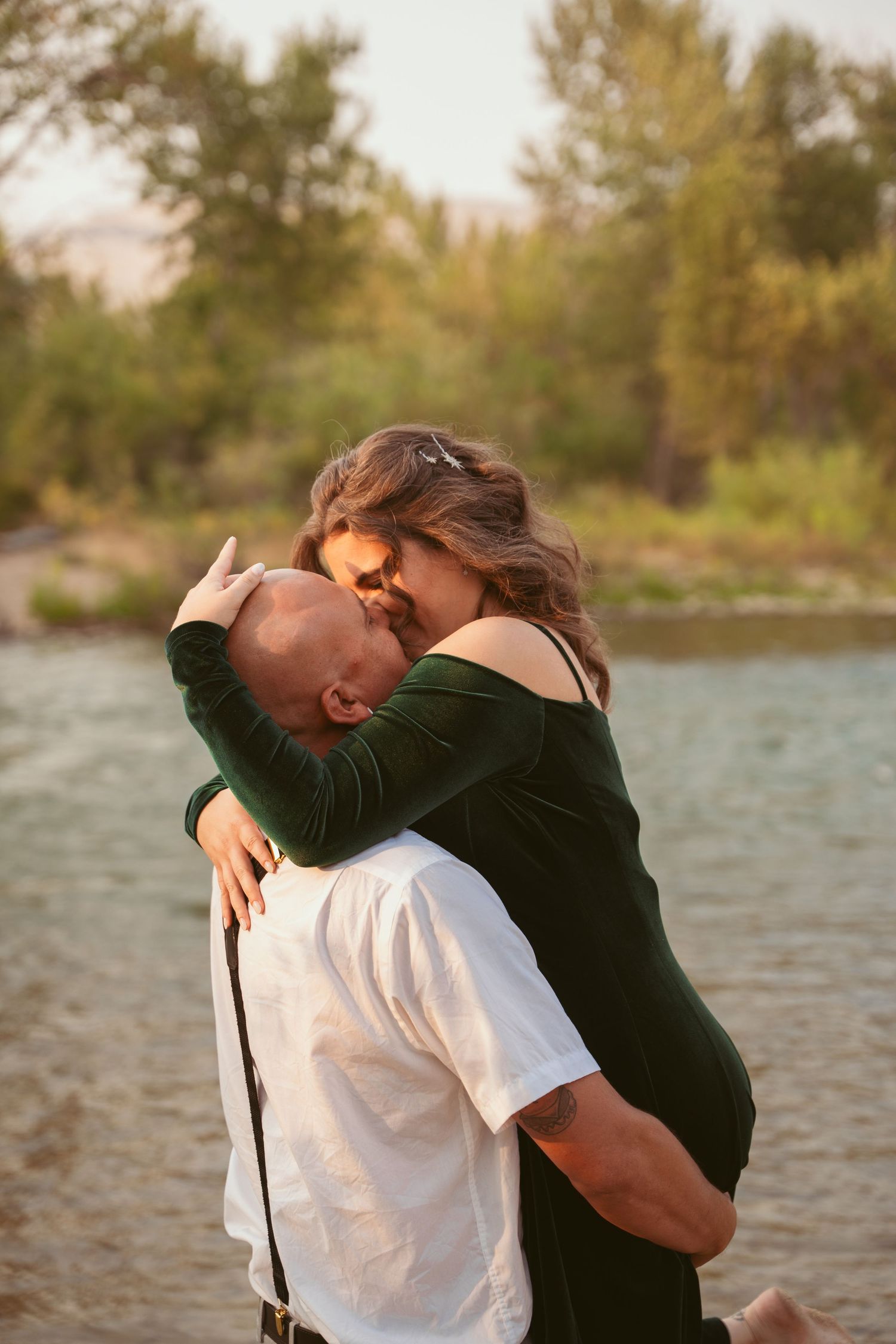 A couple shares a passionate embrace during their lakeside photo session.