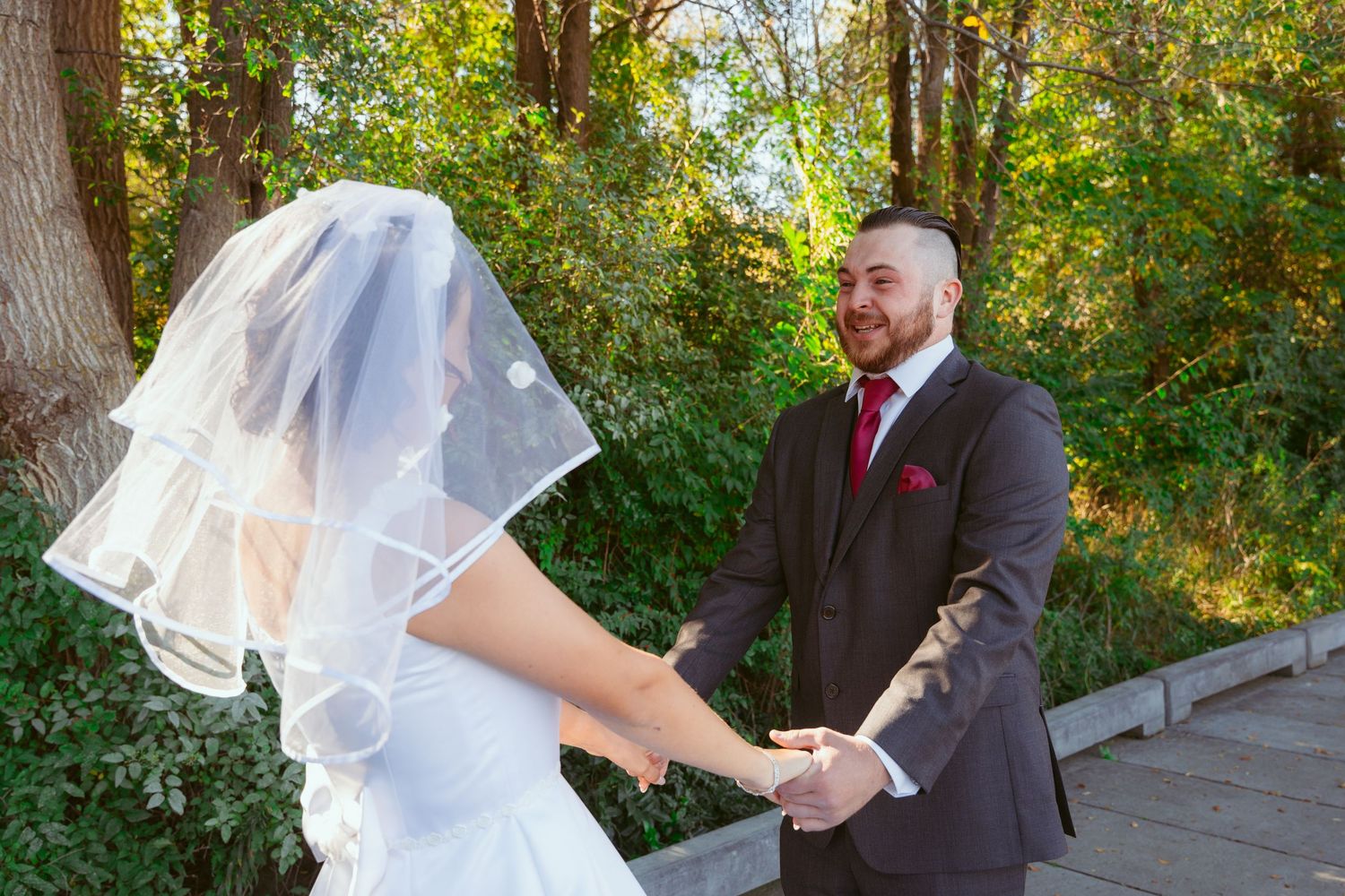 A couple holds hands during their outdoor wedding first look.