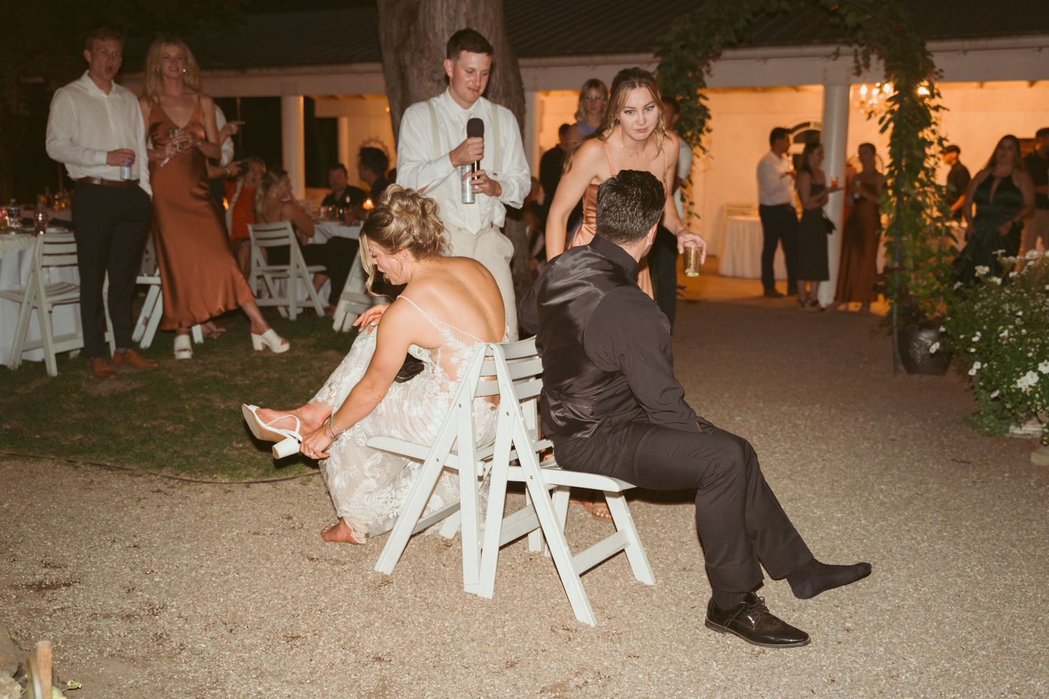 Wedding guests relaxing in chairs during outdoor evening reception.