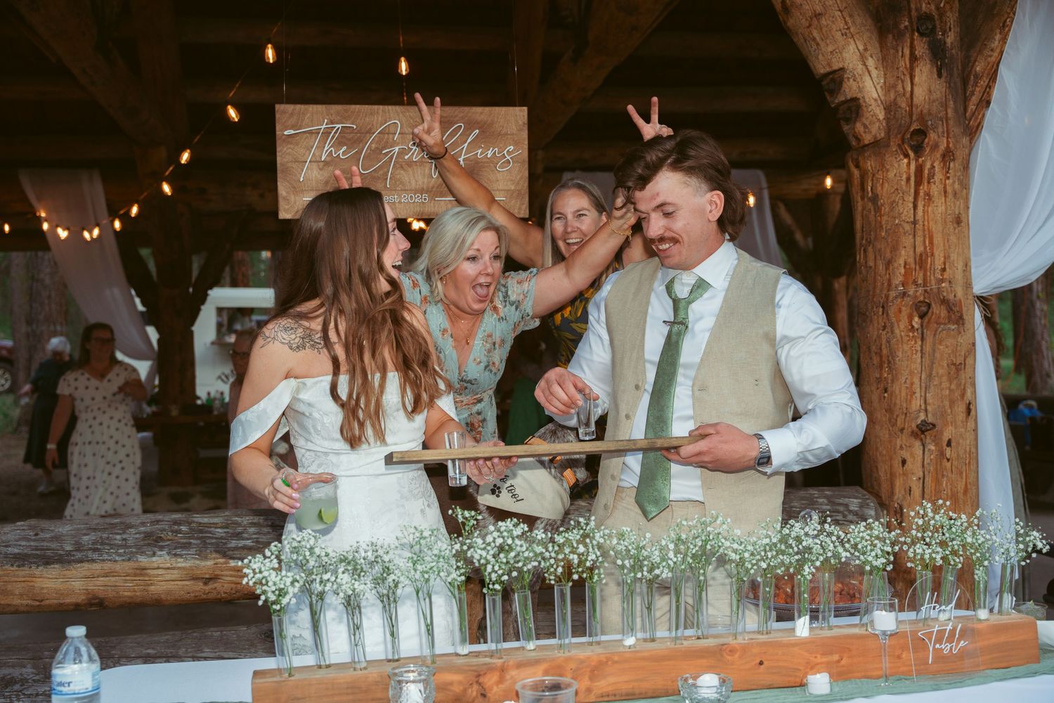 Wedding celebration in a rustic wooden barn with string lights and white decor.