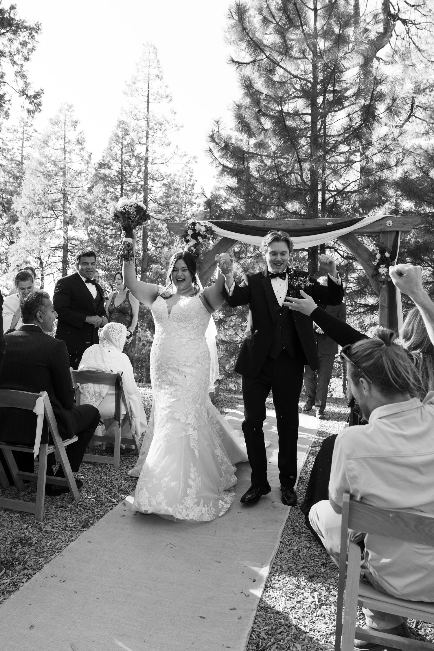 Black and white photos showing the celebratory moments after a forest wedding ceremony.