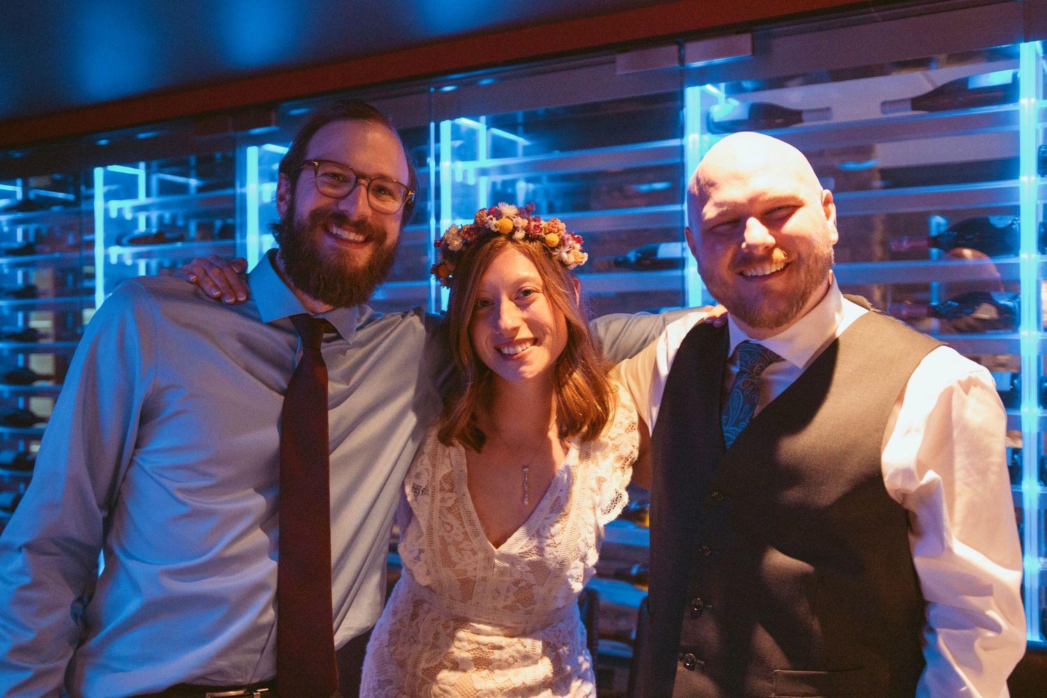 Wedding reception gathering with blue accent lighting and brick wall atmosphere.
