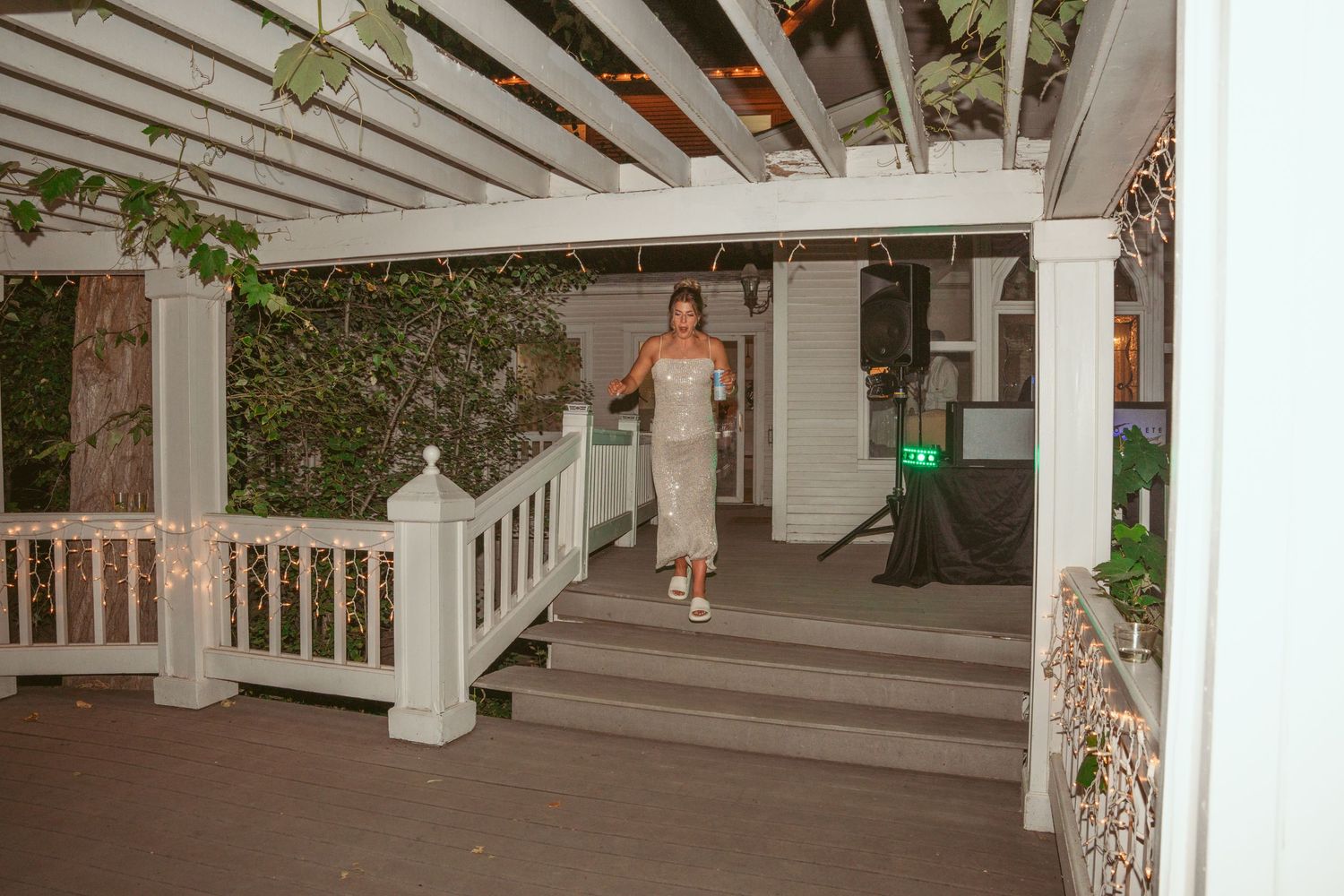 A covered porch entrance with white railings and greenery at a wedding venue.