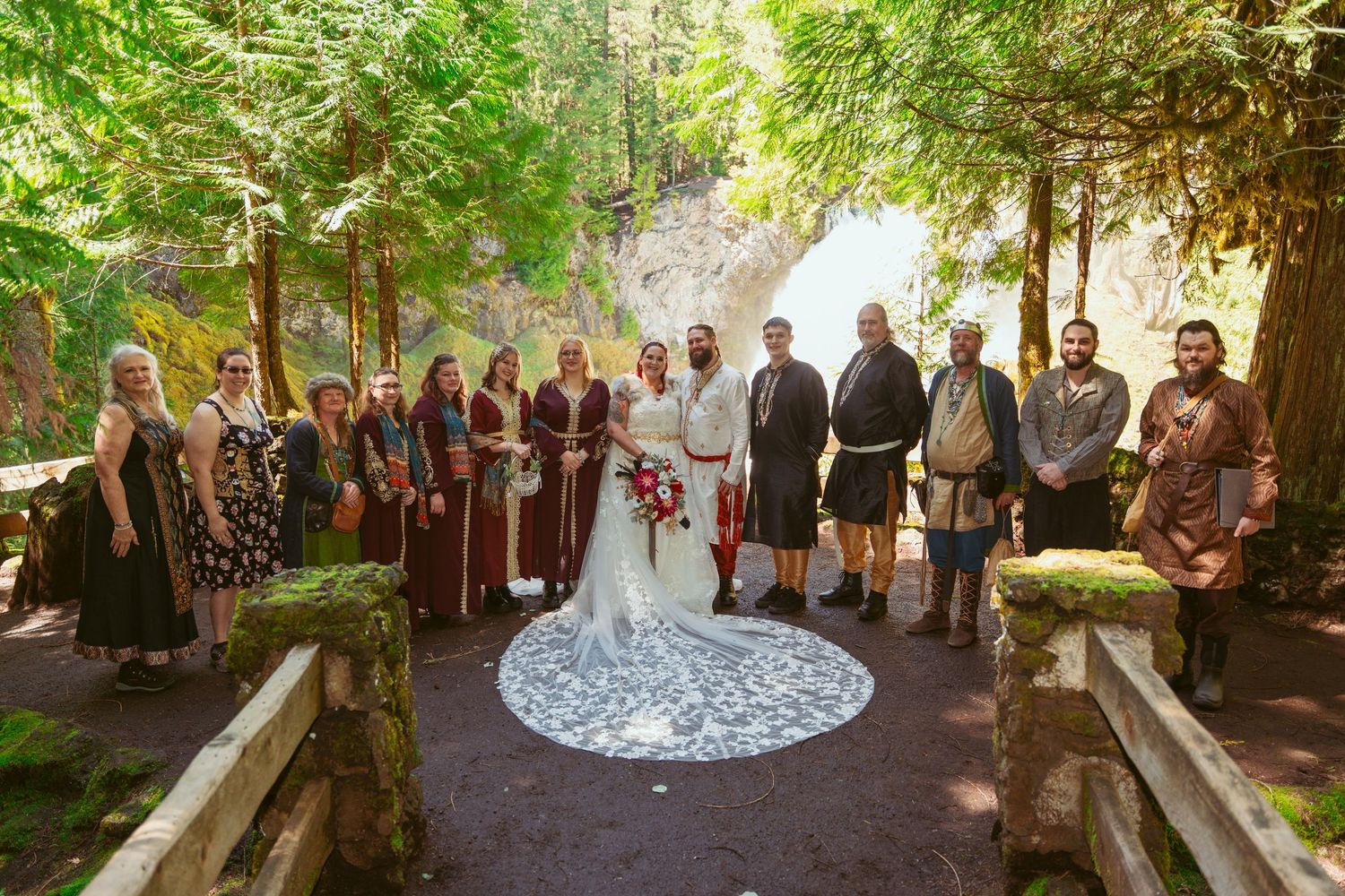 A wedding ceremony in a lush outdoor garden setting with guests gathered around.