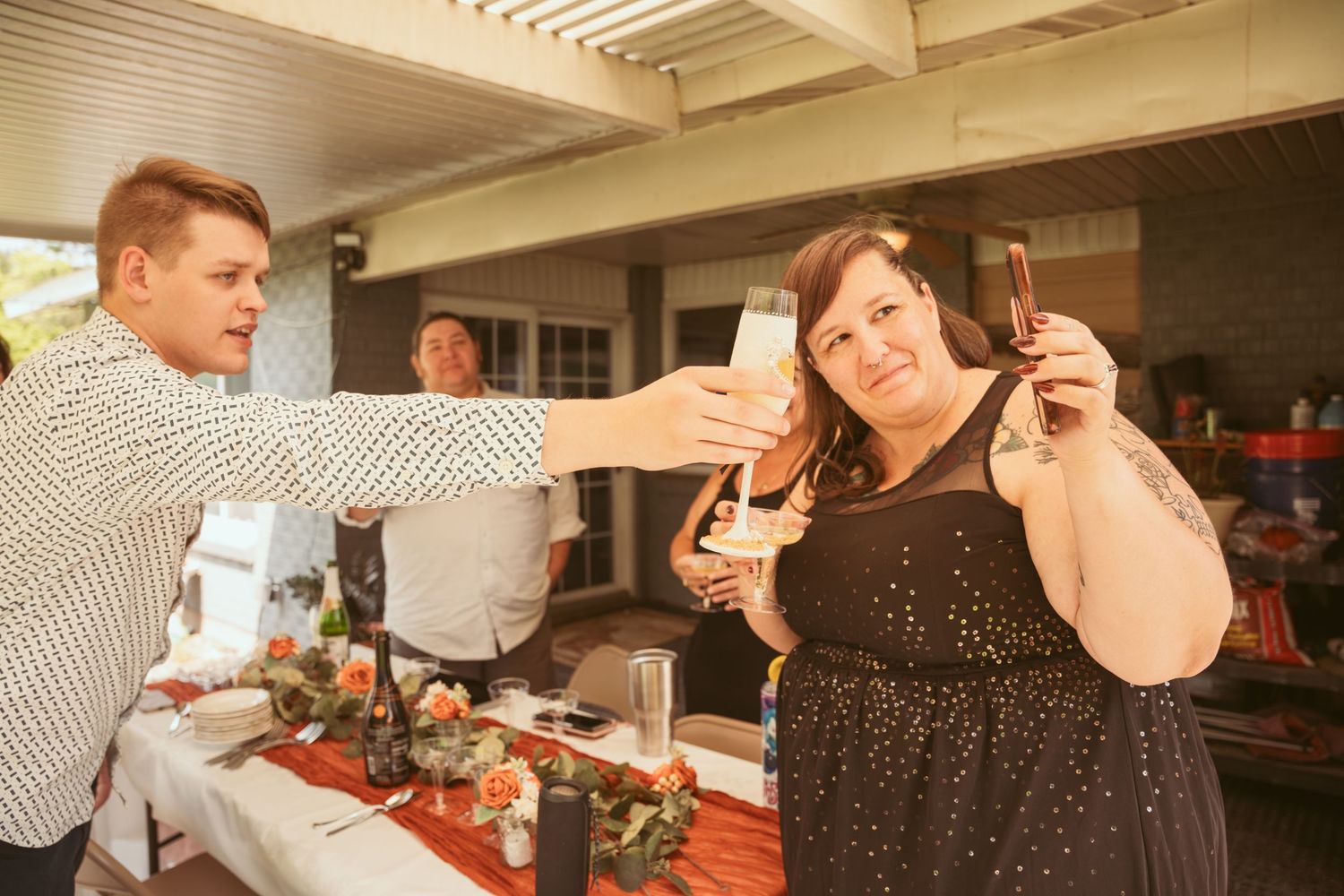 Indoor celebration with people dancing under wooden beam ceiling.