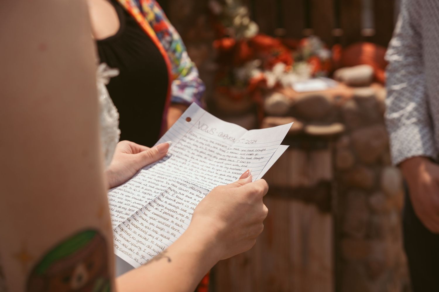 Close-up of hands holding wedding ceremony papers with text.