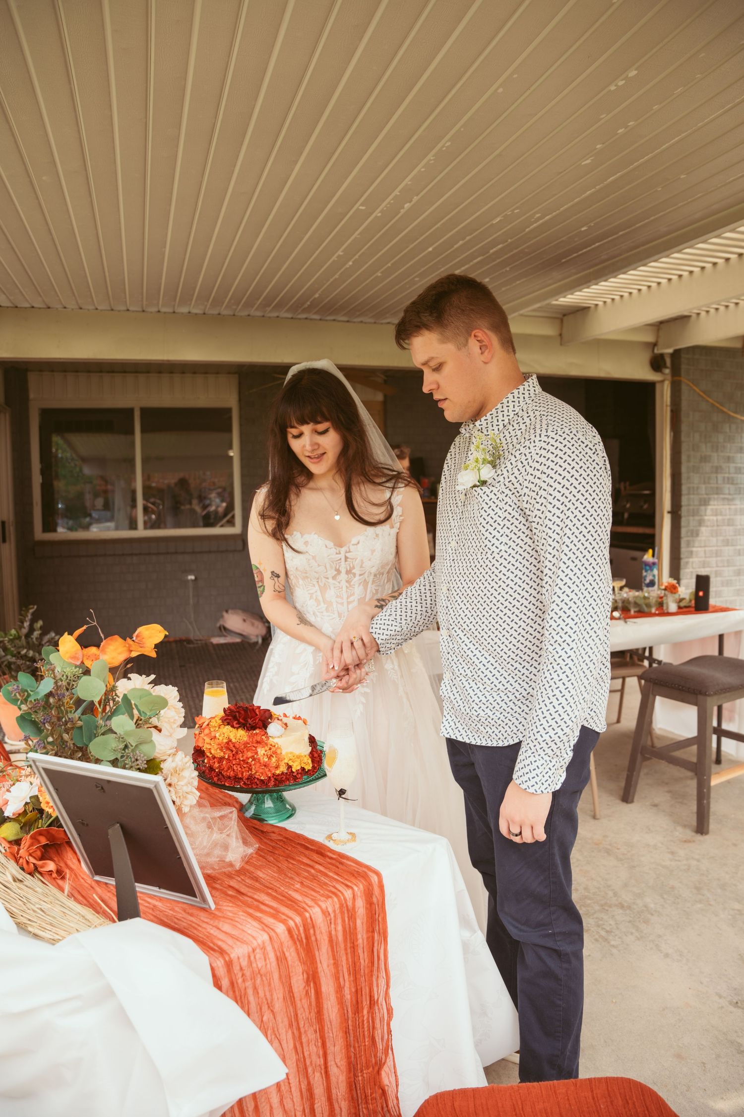 A couple shares an intimate moment during their wedding reception near a decorated dessert table.
