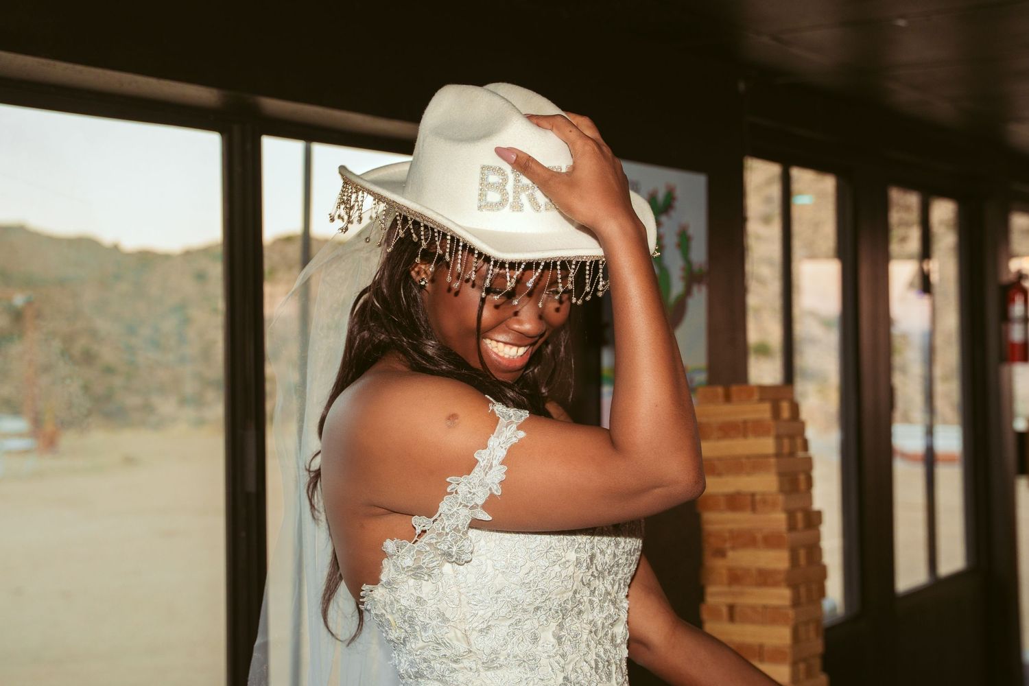 Wedding celebration in a rustic outdoor venue with string lights overhead.