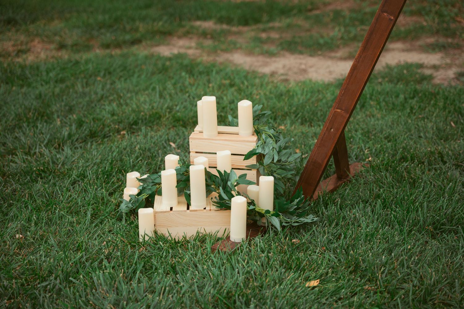 Wooden blocks and red fabric arranged on grass in a decorative outdoor setup.