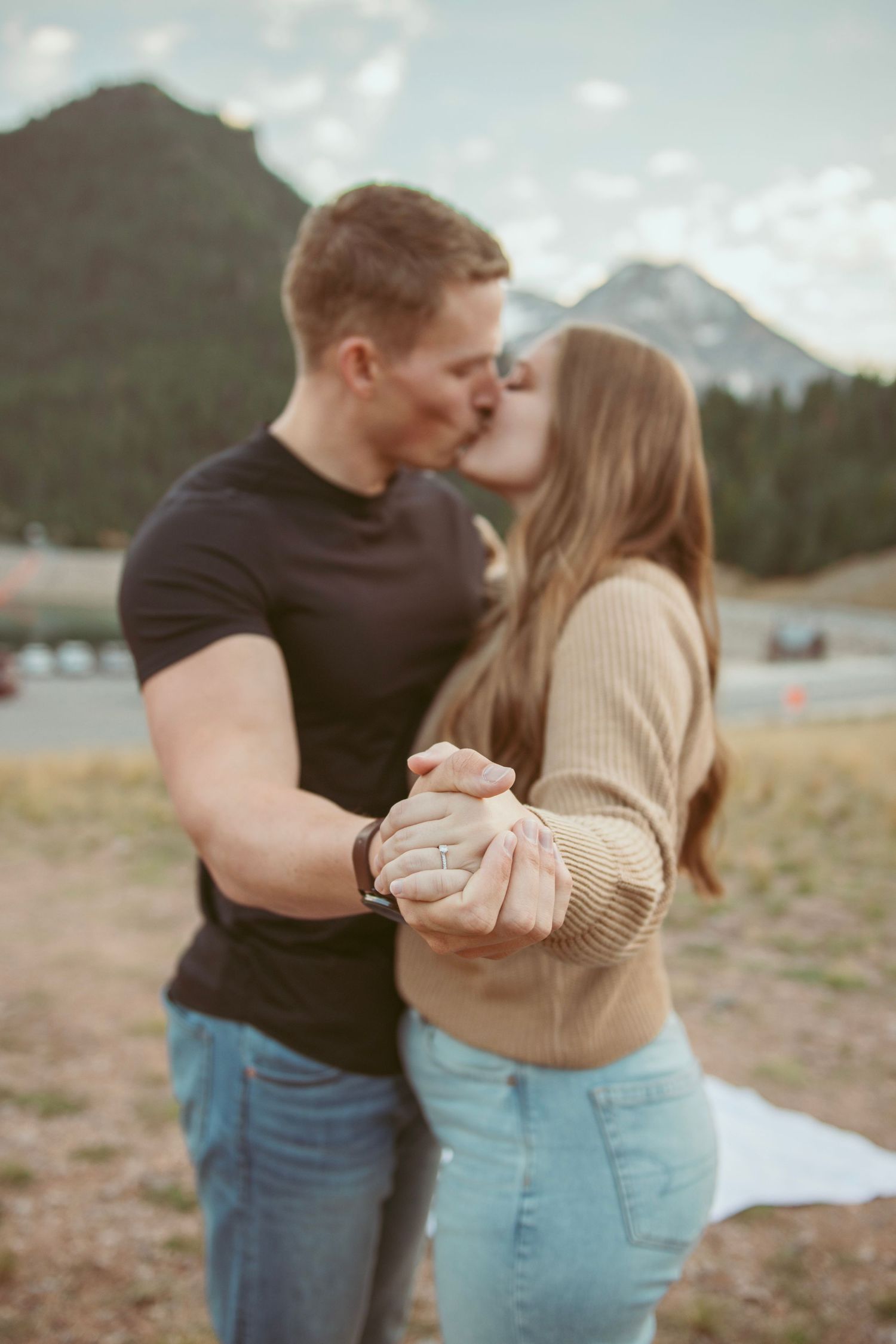 Romantic moment shared between a couple with mountains visible in the background.