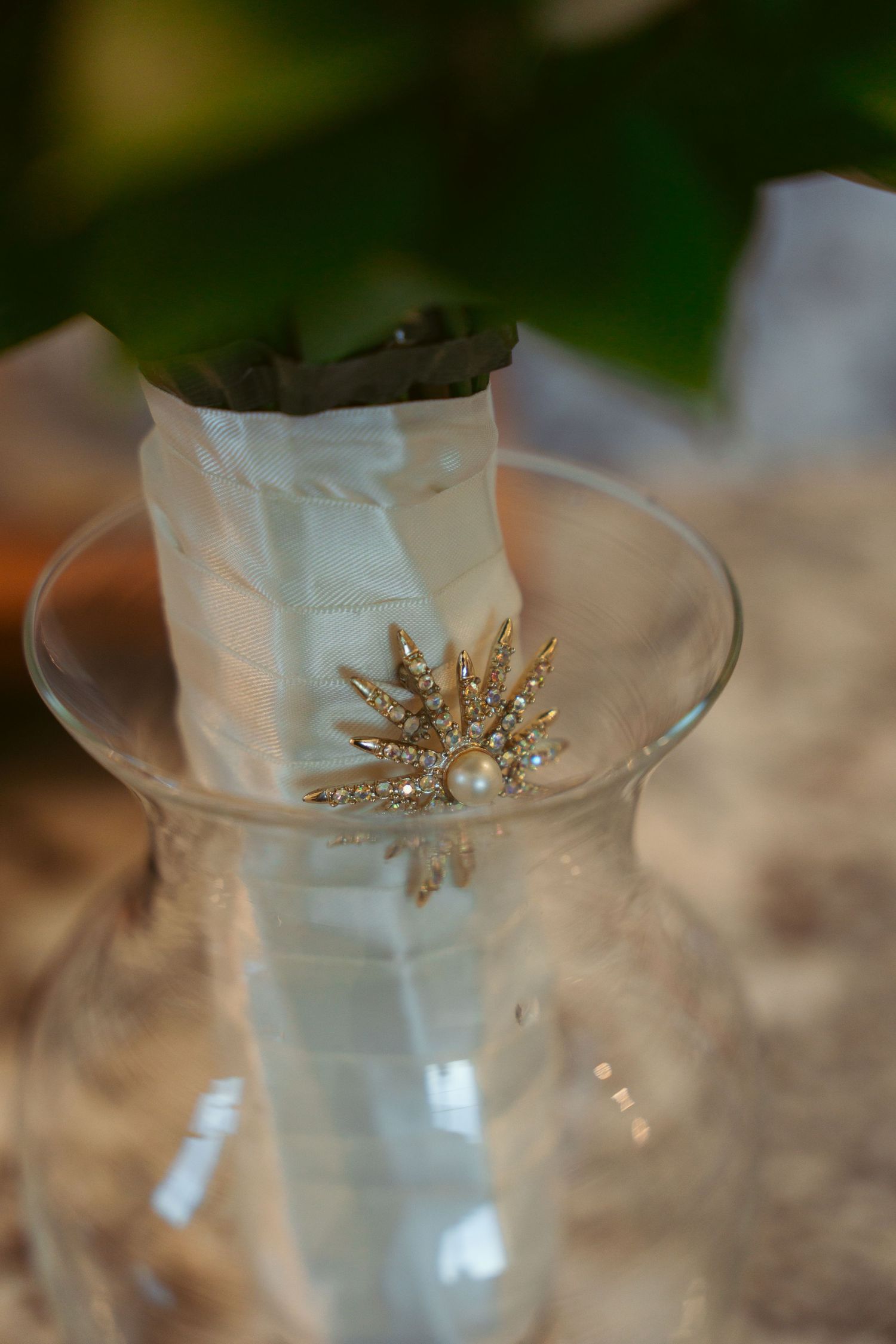 Decorative pearl and crystal hair accessories in glass vase.