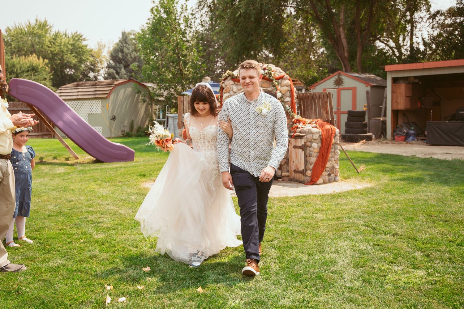 Dancing and celebrating on a sunny lawn with decorative elements in the background.