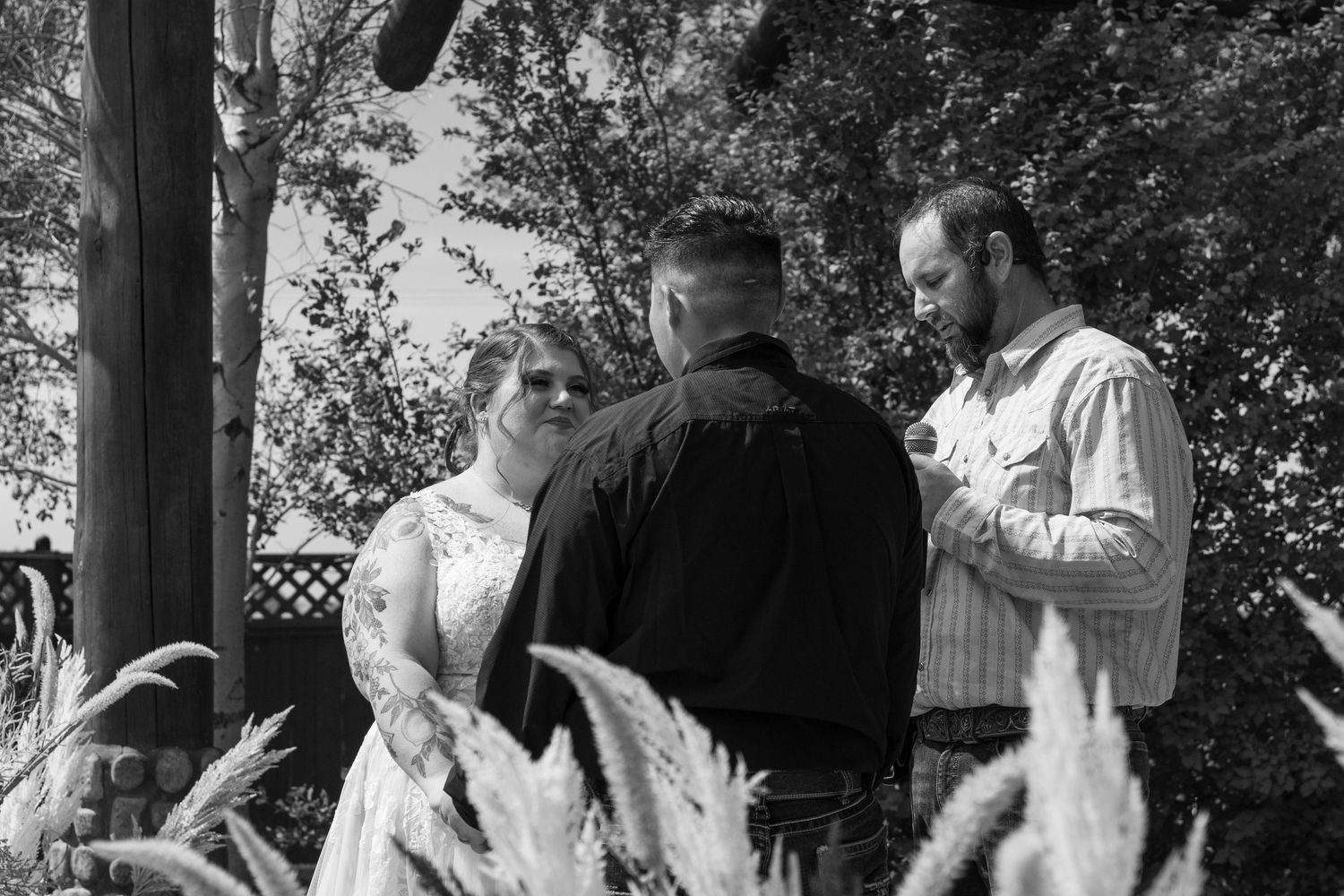 Black and white photo capturing joyful moments during outdoor wedding celebration.