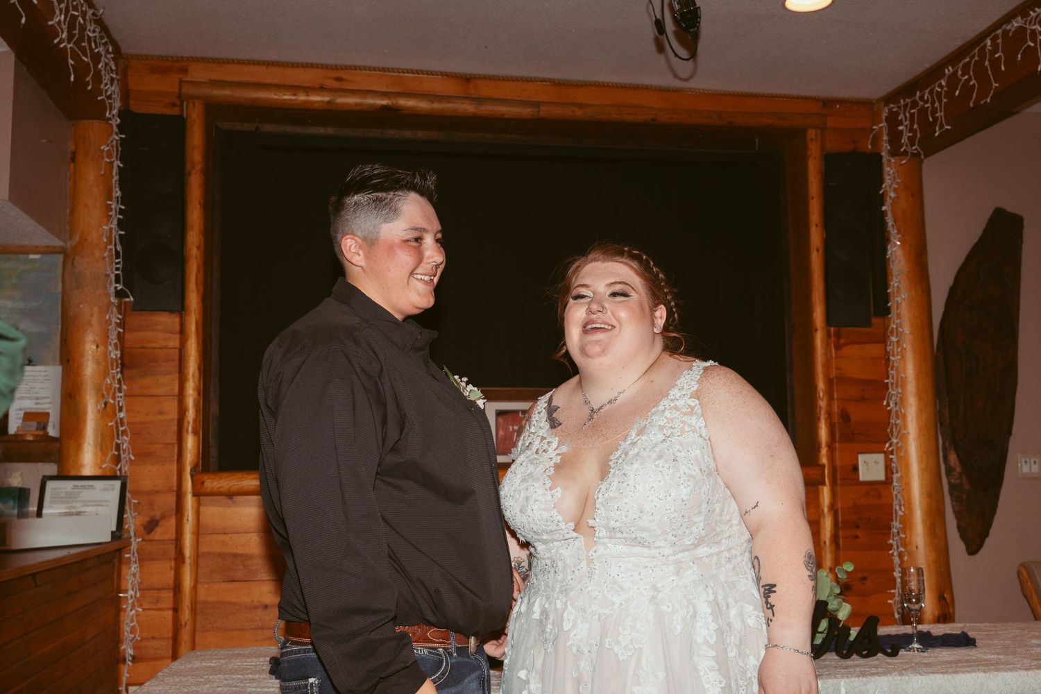 Indoor wedding reception with rustic wooden decor and dance floor celebrations.