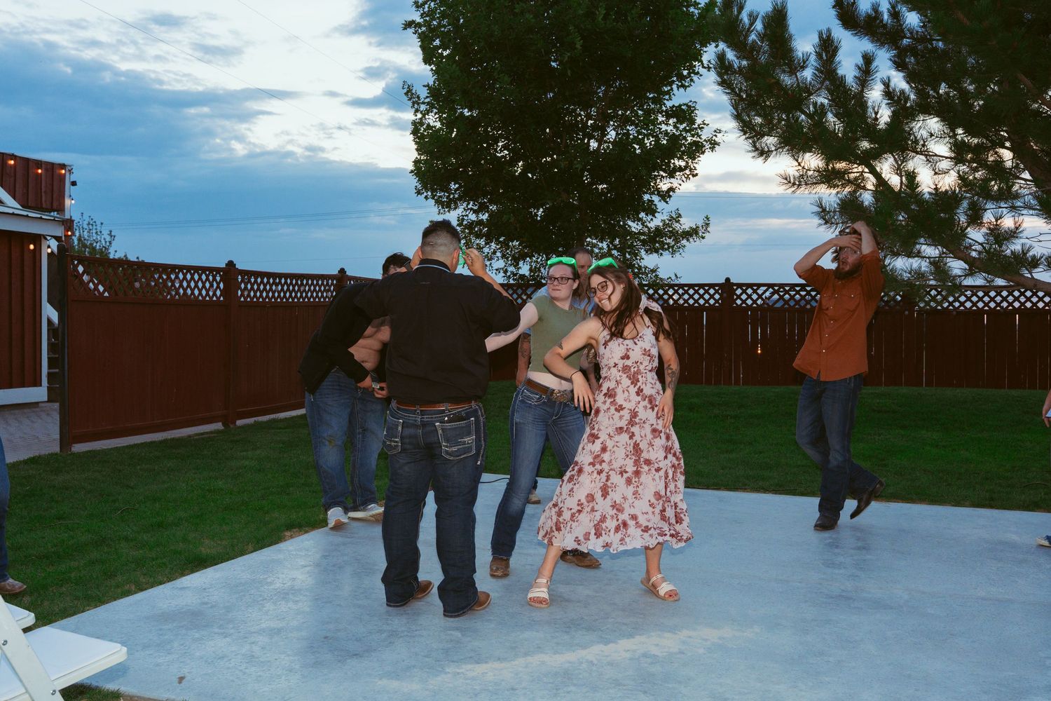 Group dancing together on an outdoor patio dance floor during a celebration.