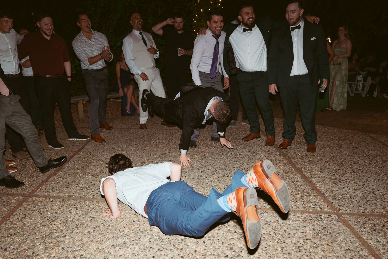 Guests dancing energetically at a wedding reception on an outdoor patio.