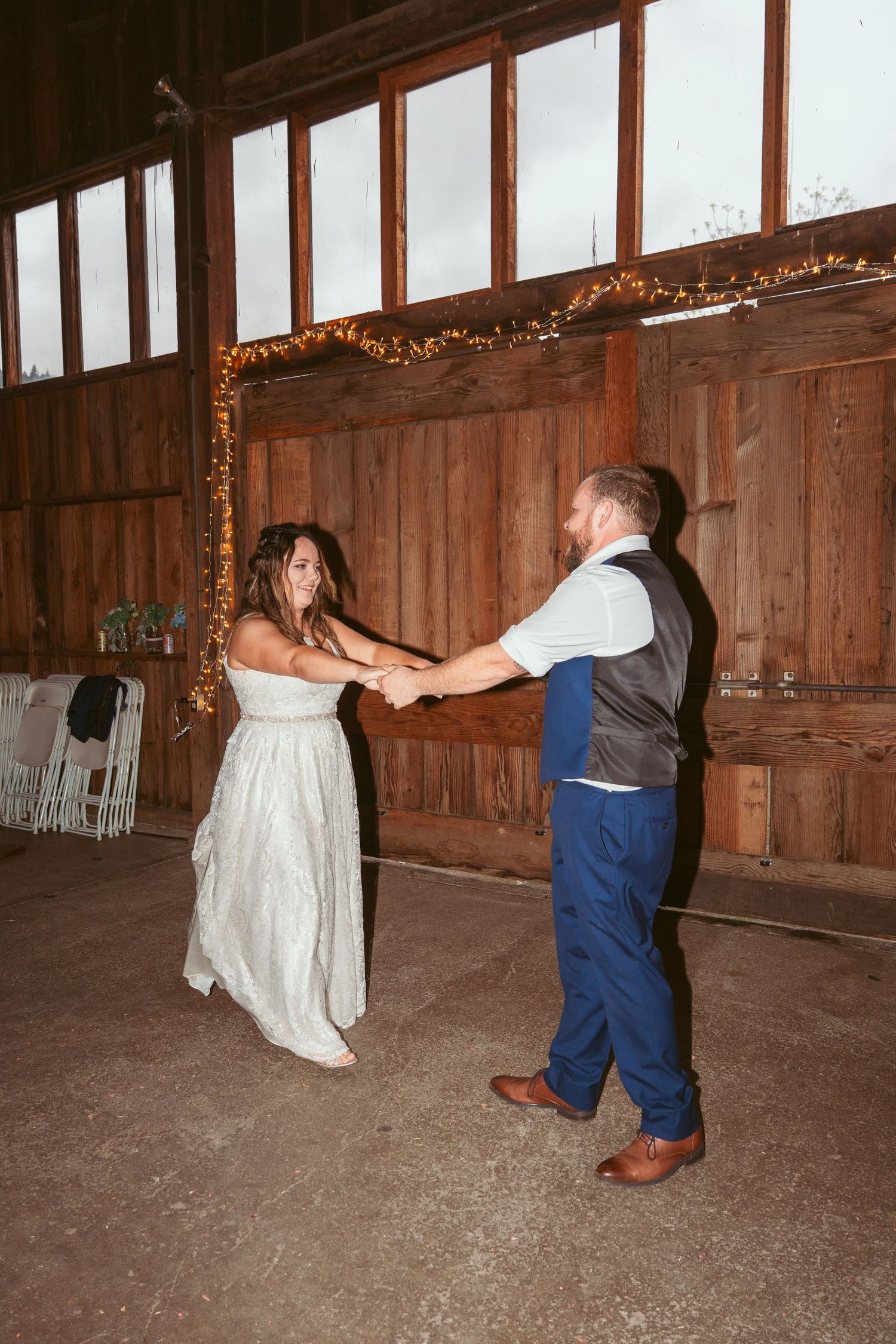 A dance sequence showing spinning movements in a barn with string lights.