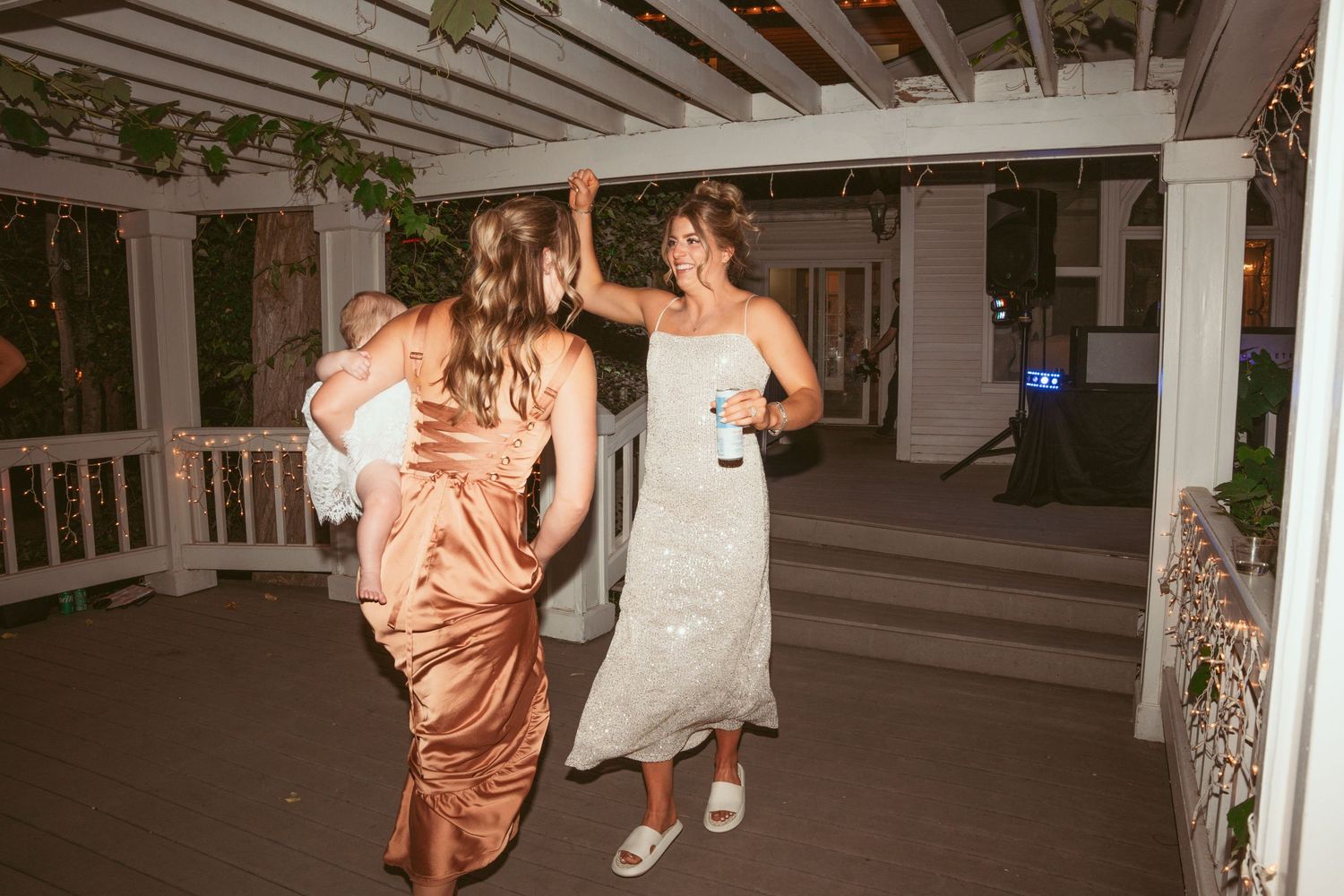 Wedding reception dance floor under wooden beams with evening lighting.