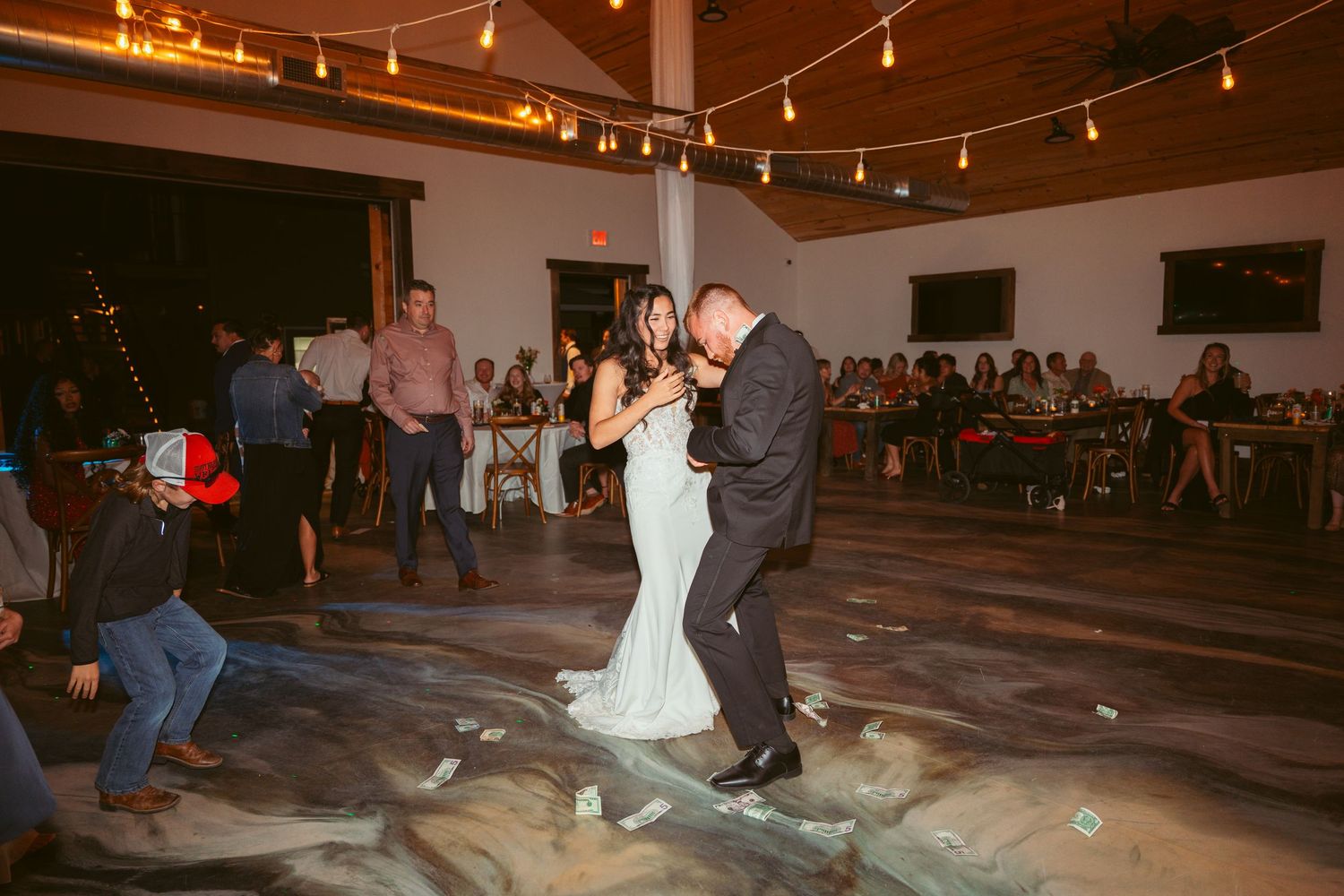 Wedding celebration in a rustic indoor venue with warm lighting and wooden floors.