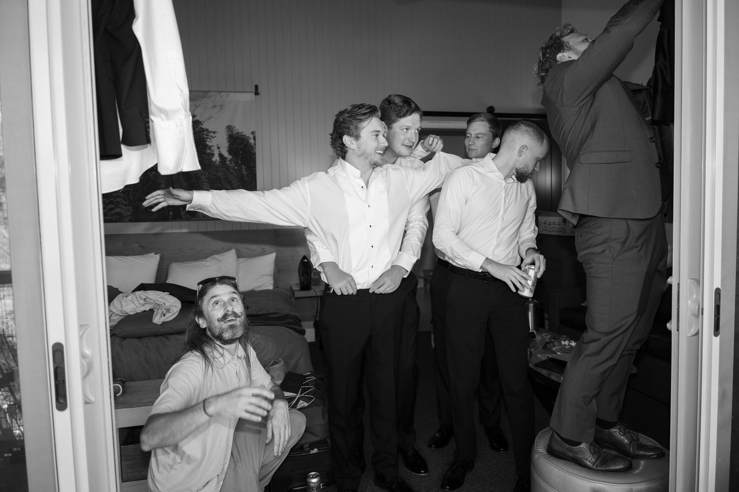 Wedding party members sharing casual moments and conversations in an indoor setting.